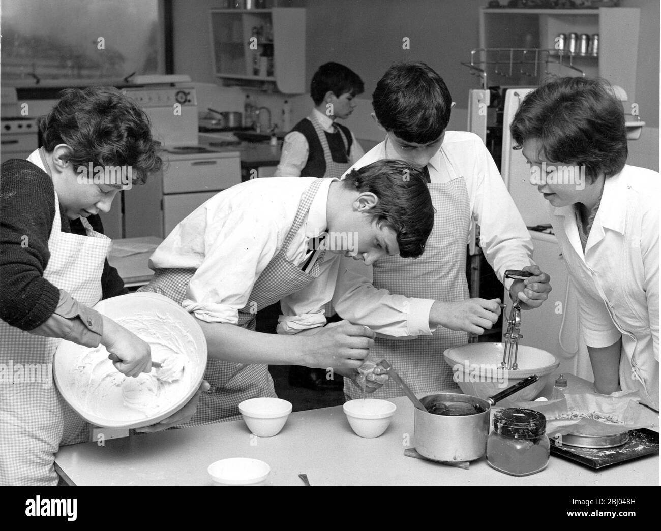 Cooking in the Classroom under the eye of their teacher Miss Moira Wright with David Mills, Martin Wilson and David Warner who are preparing chocolate meringues Westgate County Secondary School 8 February 1966 Stock Photo