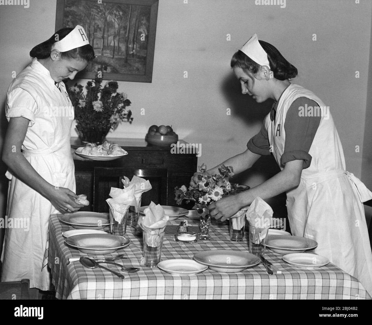 Pupils of the Hurlingham Secondary School demonstrate table-laying as part of their Domestic Science studies at an exhibition. 1947 Stock Photo