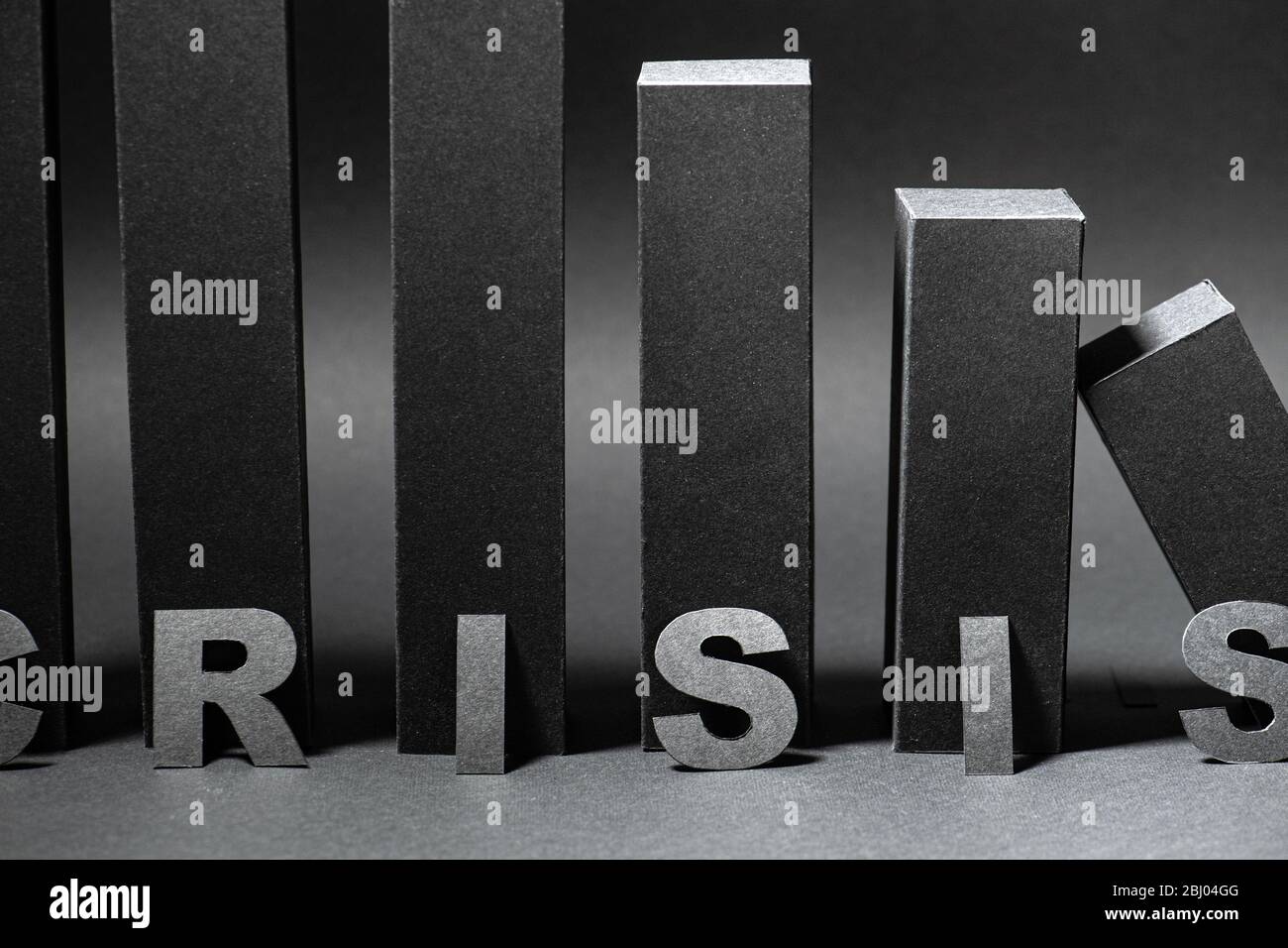 Crisis word over falling 3d bar chart made in black color over shades of gray Stock Photo