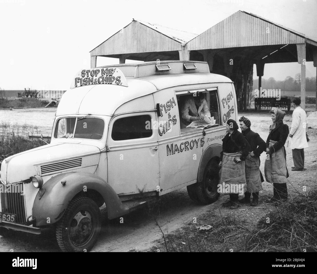 Fish and Chips for women farm workers on a chilly March day 1948. The van is a converted government ambulance. - - An enterprising ex Royal Naval Chief Steward has sunk his gratuity into a mobile fish and chip shop and now take hot dinners to workers in the fields and villages around the Dartford rural area, Kent. - Once and twice a week he visits the various farms, each on a different day, but mainly between the lunch hours or just before. Workers in the fields now know that opn a certain day or two days during the week they have no need to take bread and cheese or sandwiches for lunch - for Stock Photo