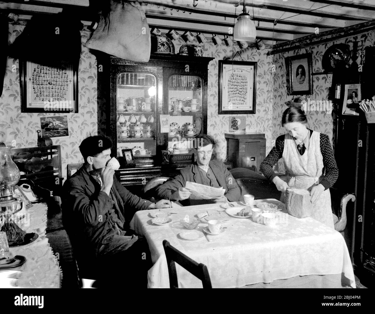 A farmhouse tea in Wales 1950. The house was lit with bottled gas and salt pork hung from the ceiling Stock Photo