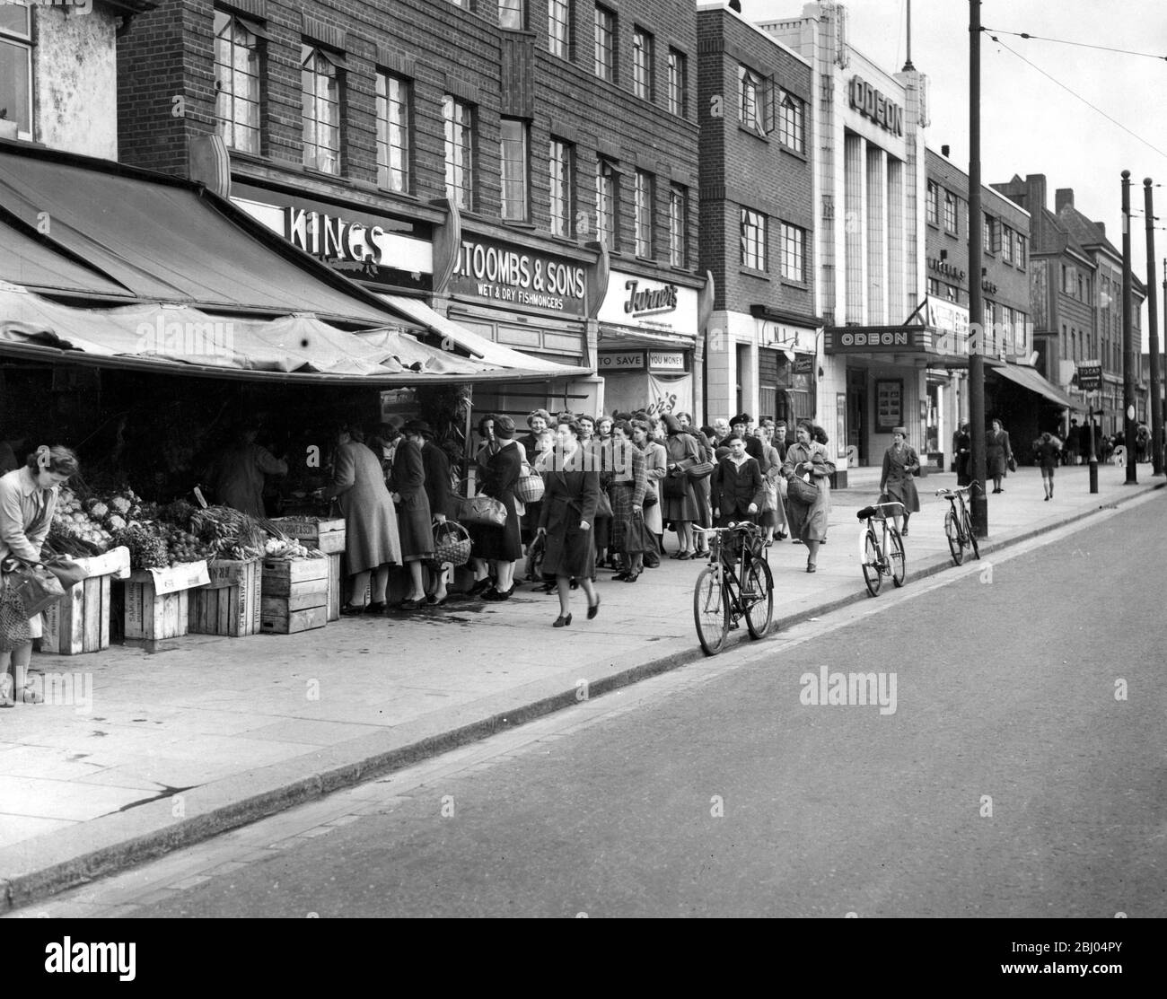 Bread queues in Bexleyheath in front of a parade of shops. 12th November 1953. Stock Photo