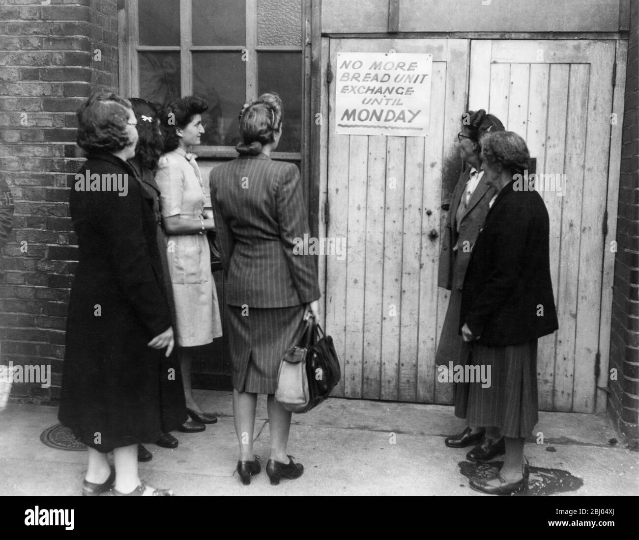 16 August 1946 - After four weeks of bread rationing, millions of surplus units were being exchanged by housewives for points to allow them to buy other goods thus causing a crisis. This London food office was one of many that had to suspend bread unit exchange. - Stock Photo