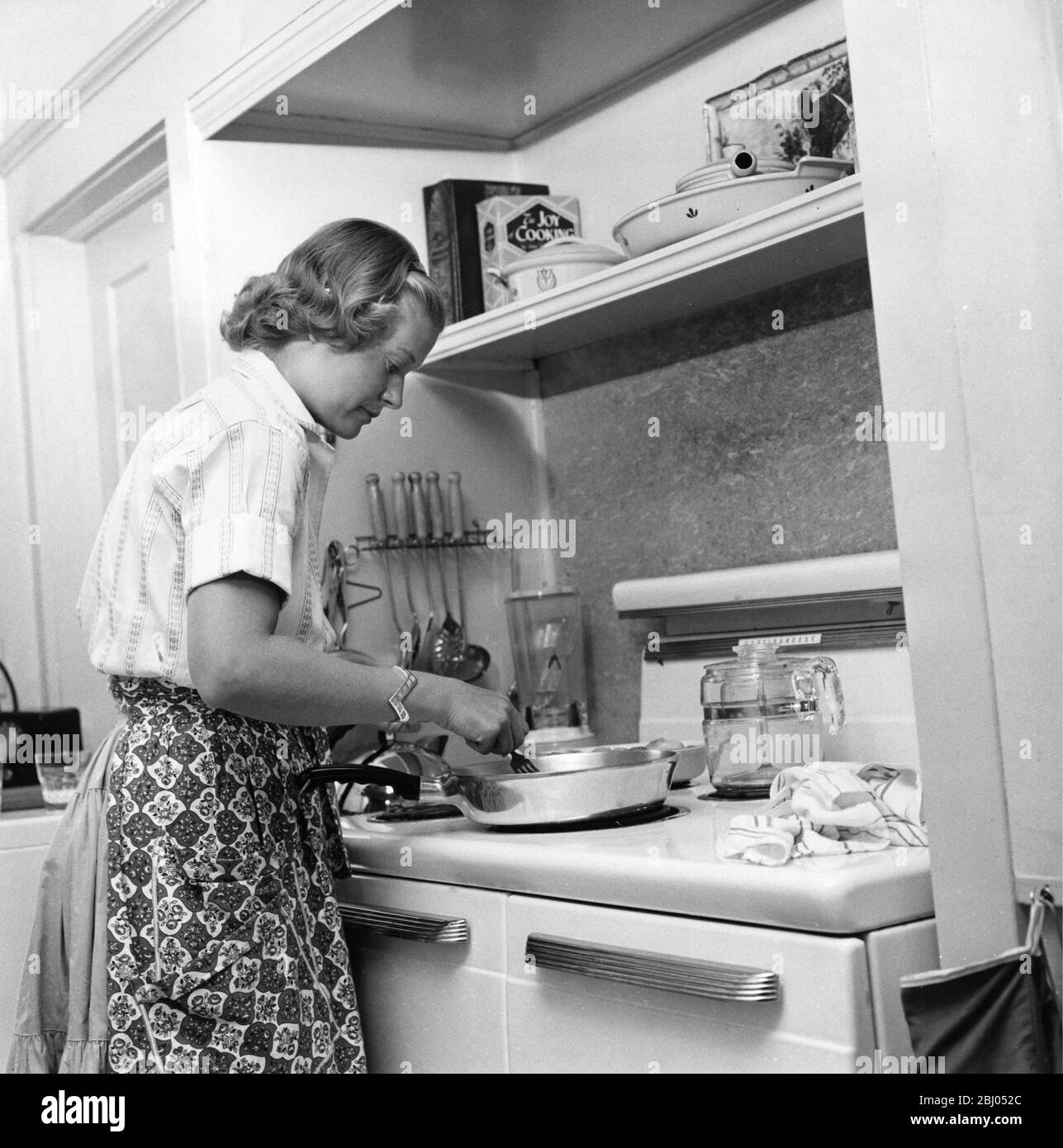USA early 1950's. Woman in her kitchen preparing a meal. Stock Photo
