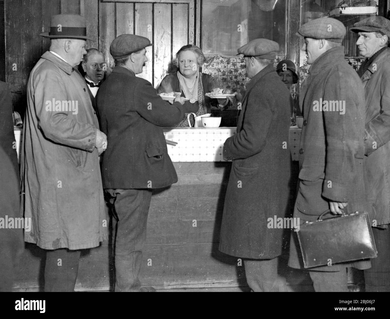 The welcome canteen, Webber Street, Waterloo Road. - Run by lady Clough Anson for unemployed. Lady Clough Anson is seen serving the men. - 21 November 1931 Stock Photo
