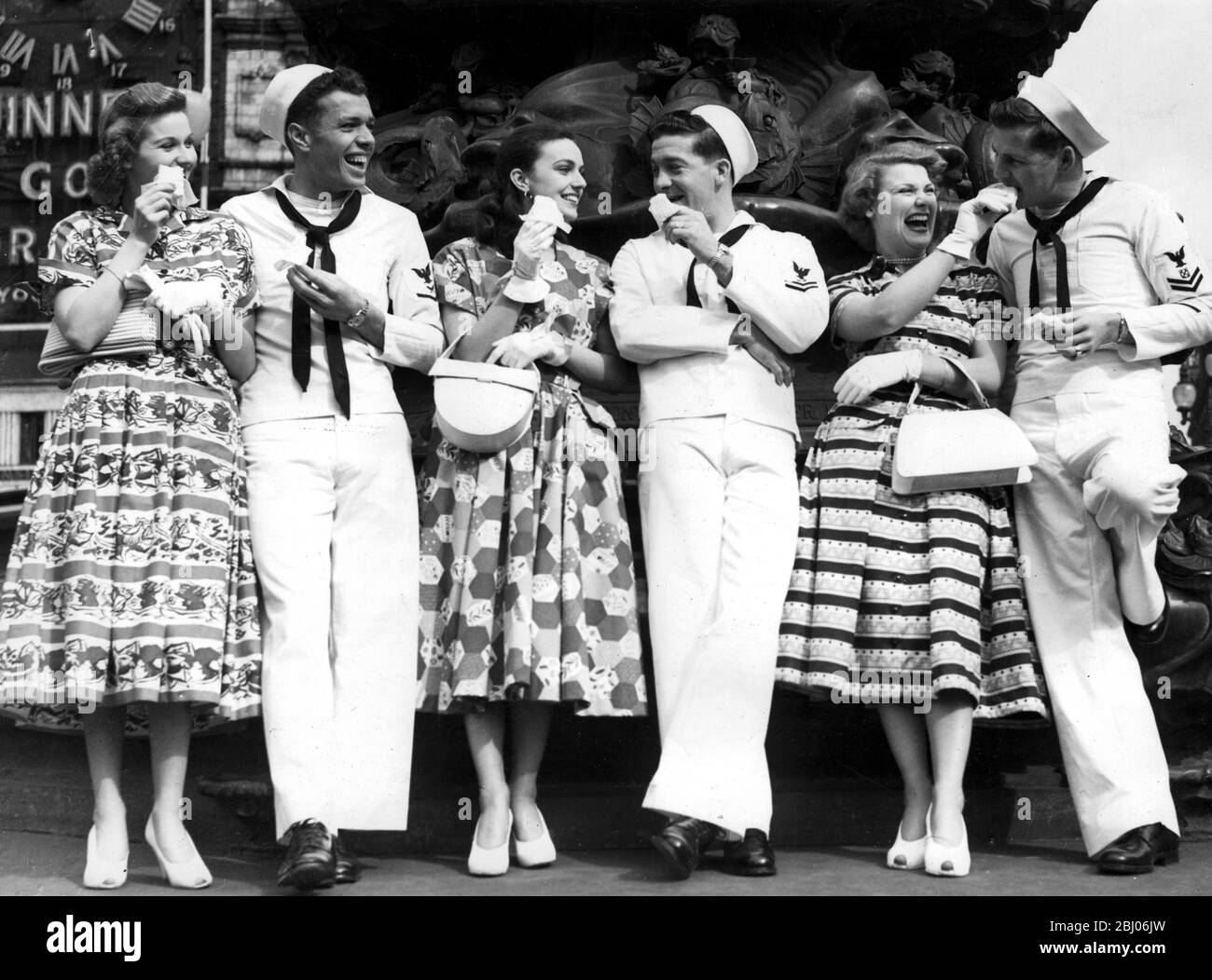 There was a spring look about Leicester Square when Empire showgirls took US sailors, wearing their summer outfits for the first time in London since 1933, around to show them the sights after they had been guest audience at the new Sinatra film On the Town - 1950s Stock Photo