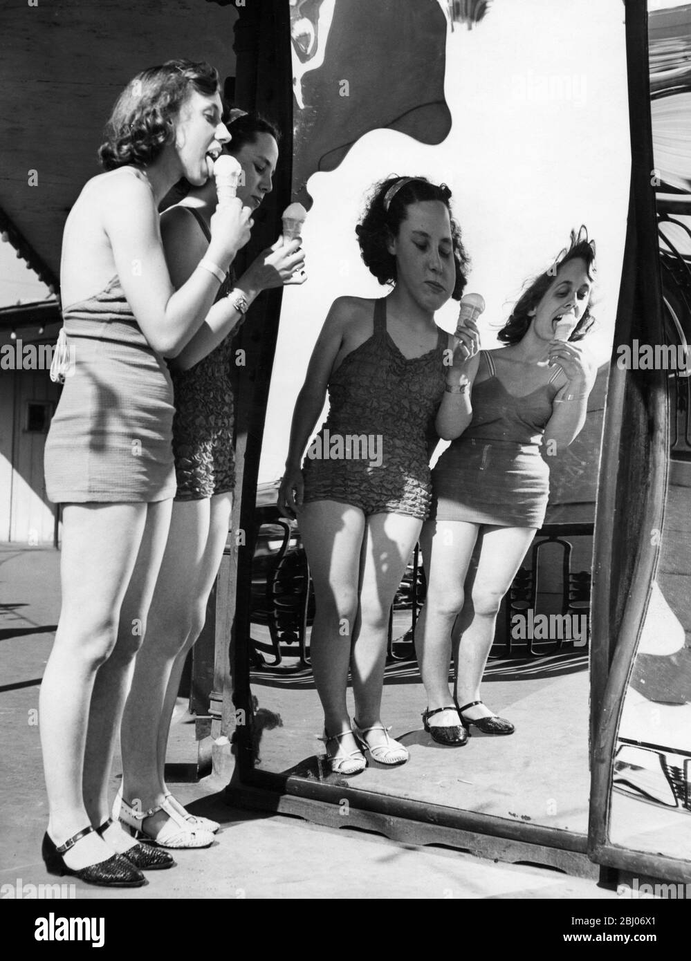 Bathing beauties eating ice creams standing in front of magic mirrors 1947 - Ramsgate Stock Photo