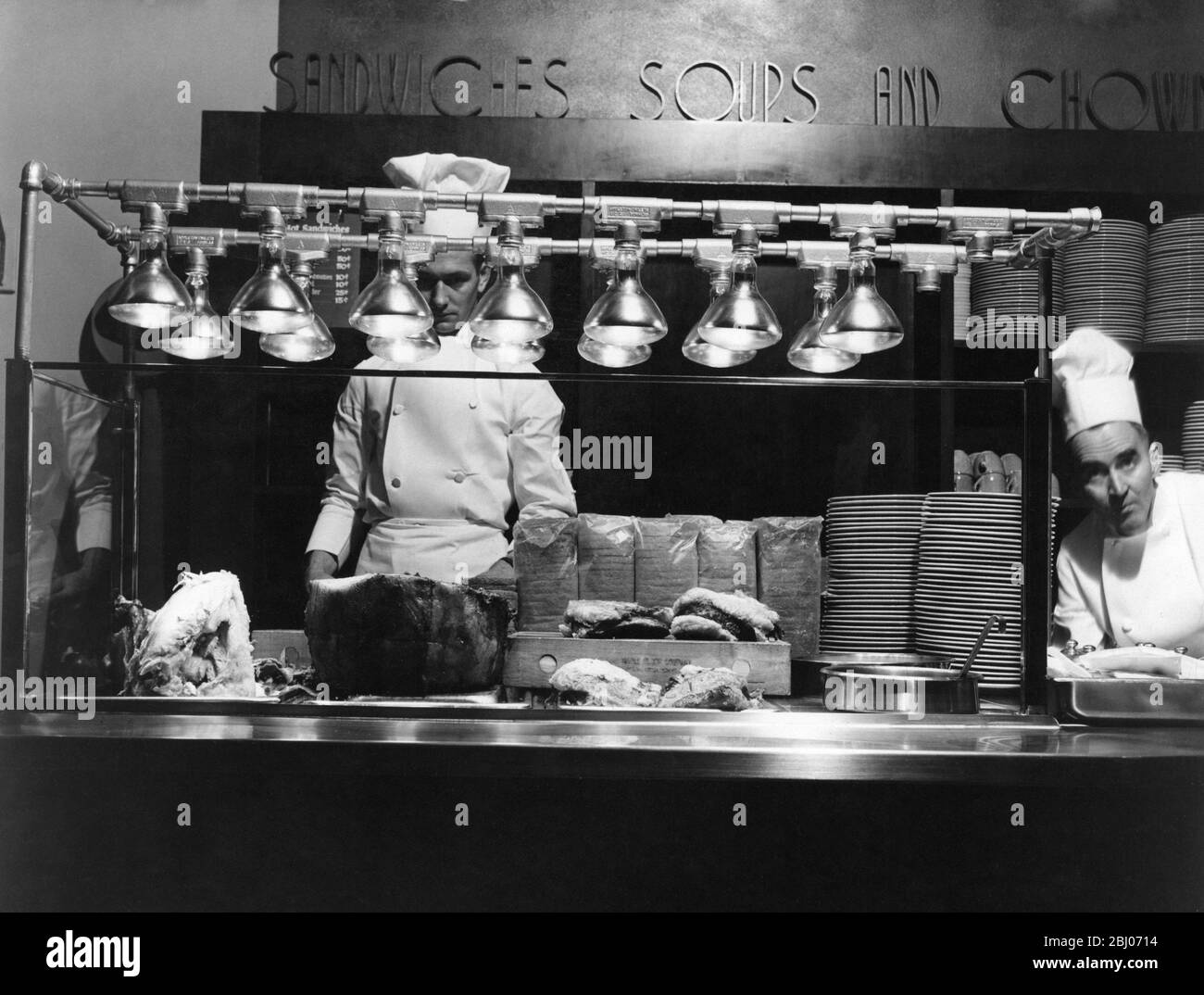 Cooking with light is one of the latest applications of infrared lamps , according to General Electric heat lamp specialists . Here a combination display and serving table in a buffet style restaurant is effectively serviced by both heat and light by a bank of 14 250 watt heat lamps . Meat , sandwiches , soup and chowder are displayed and served from this table . The natural colours or rare raost beef , juicy hams , and tender chickens are brought out by the light , while the food is kept piping hot by the infrared radiation Stock Photo