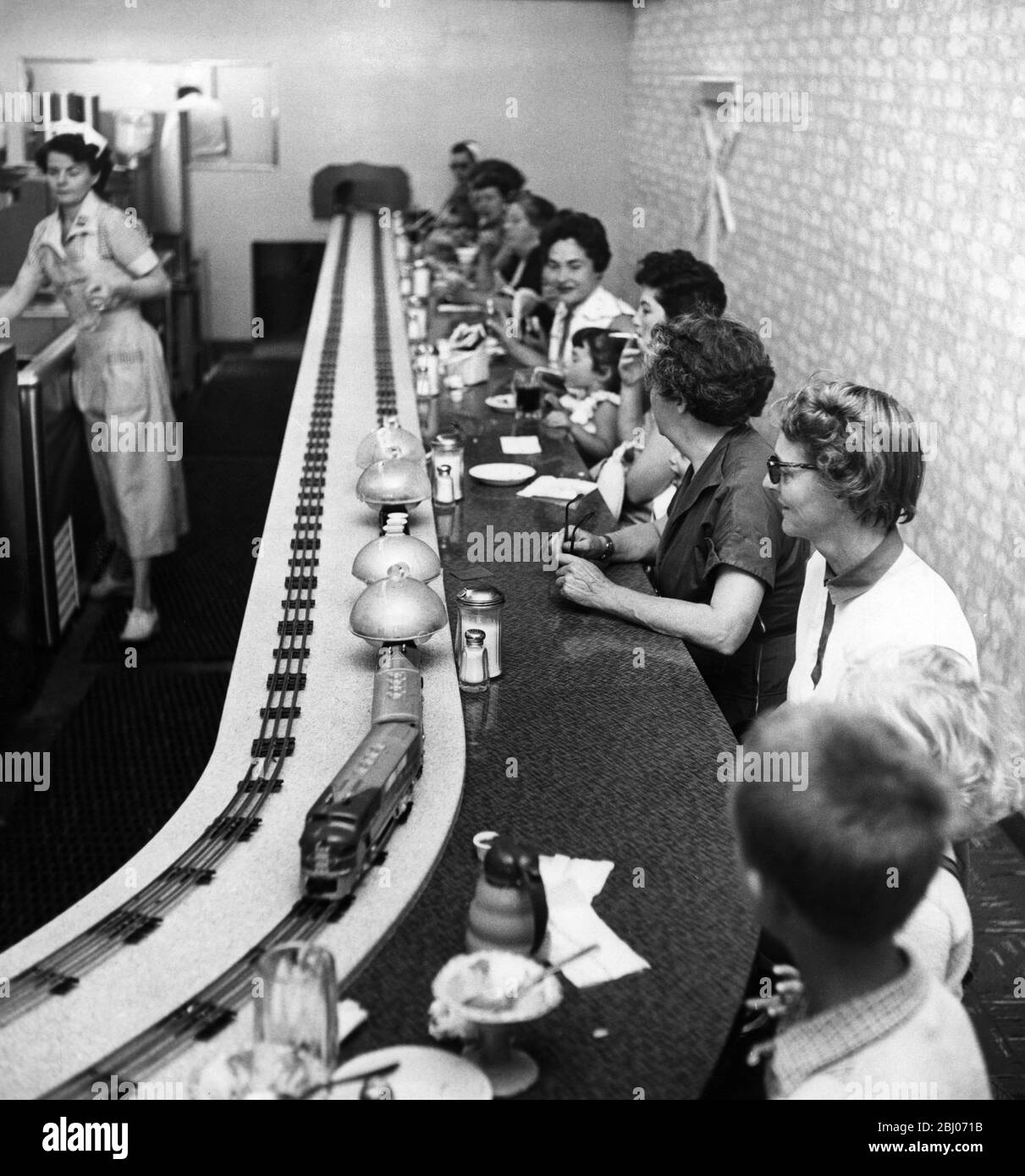 The trains stop at different stations along the counter . This is the only double rail restaurant in the world . Stock Photo