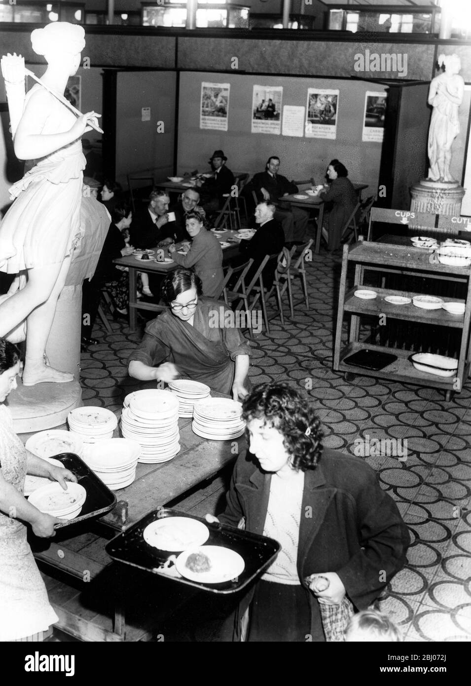 British restaurants , opened by the Londoners' Meals Service to provide good food at minimum prices , have appeared almost everywhere in London . The strangest is at the Bethnal Green Museum , in the East End , where 1,000 hot lunches can be served every day .. Customers pay tenpence or a shilling in the hall , at a booth beside a bust of Garibaldi and get their meal at a service counter , carrying it past a bus of Oliver Cromwell to the central hall , where Venus , Goddess of Love , look down on the communal scene of Londoners lunching in classic surroundings. - 16th June 1945 Stock Photo