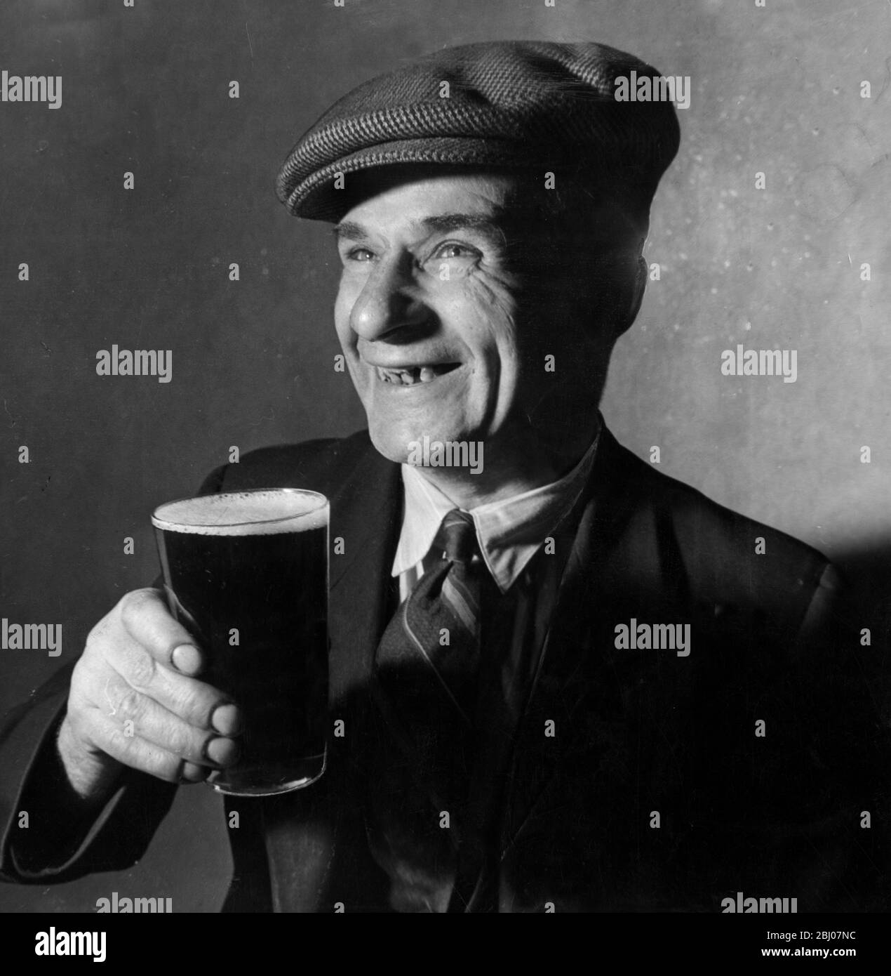 Archie McKenna , 46 year old shipyard driller of Jarrow remembers the starvation days of the 1930s and carefully watches his family budget . He drinks six pints a week. Nine pence of every pint goes to the Government in tax - - 1949 Stock Photo