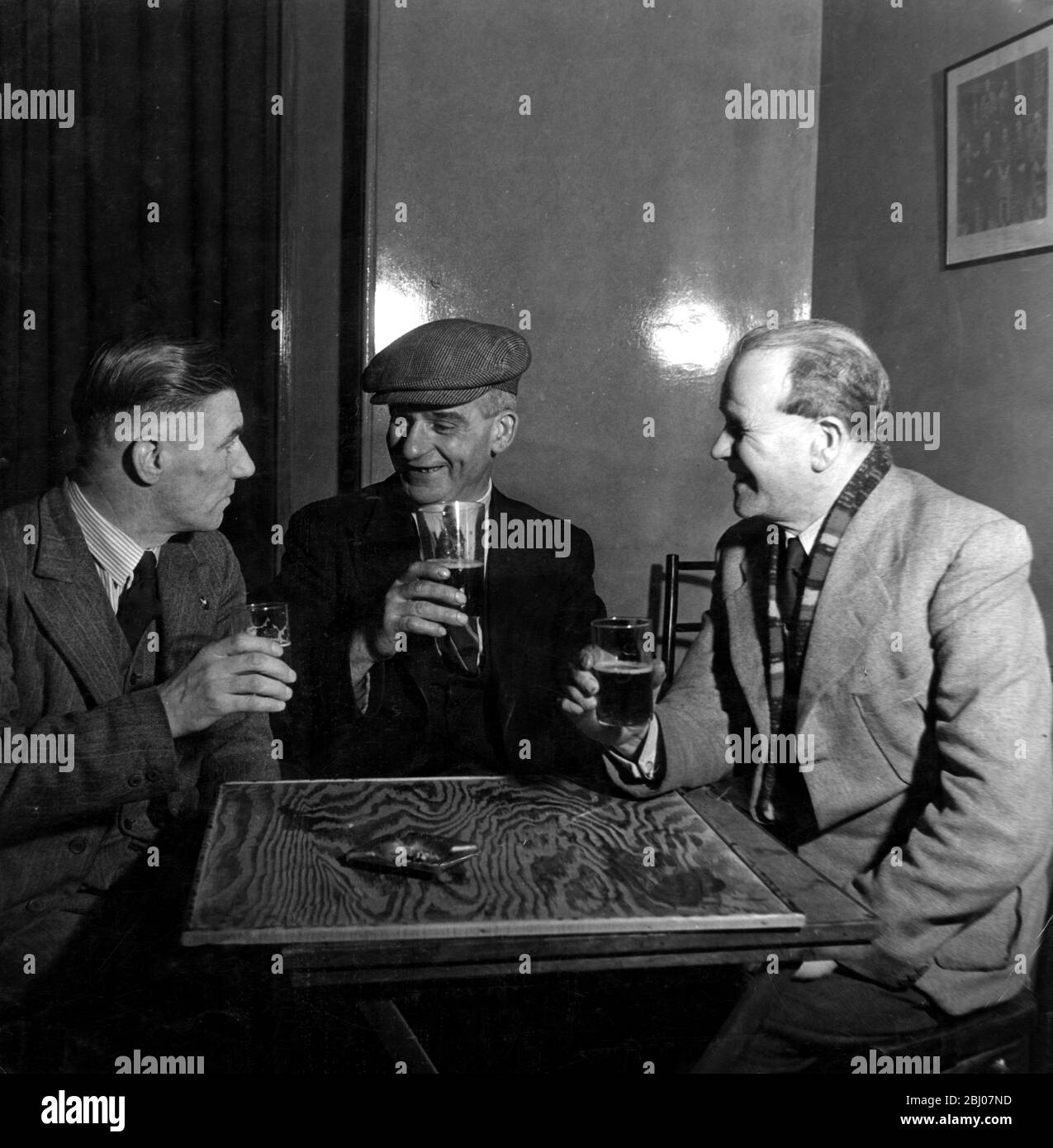 Archie McKenna (centre) , 46 year old shipyard driller of Jarrow remembers the starvation days of the 1930s and carefully watches his family budget . He drinks six pints a week. Nine pence of every pint goes to the Government in tax - - 1949 Stock Photo