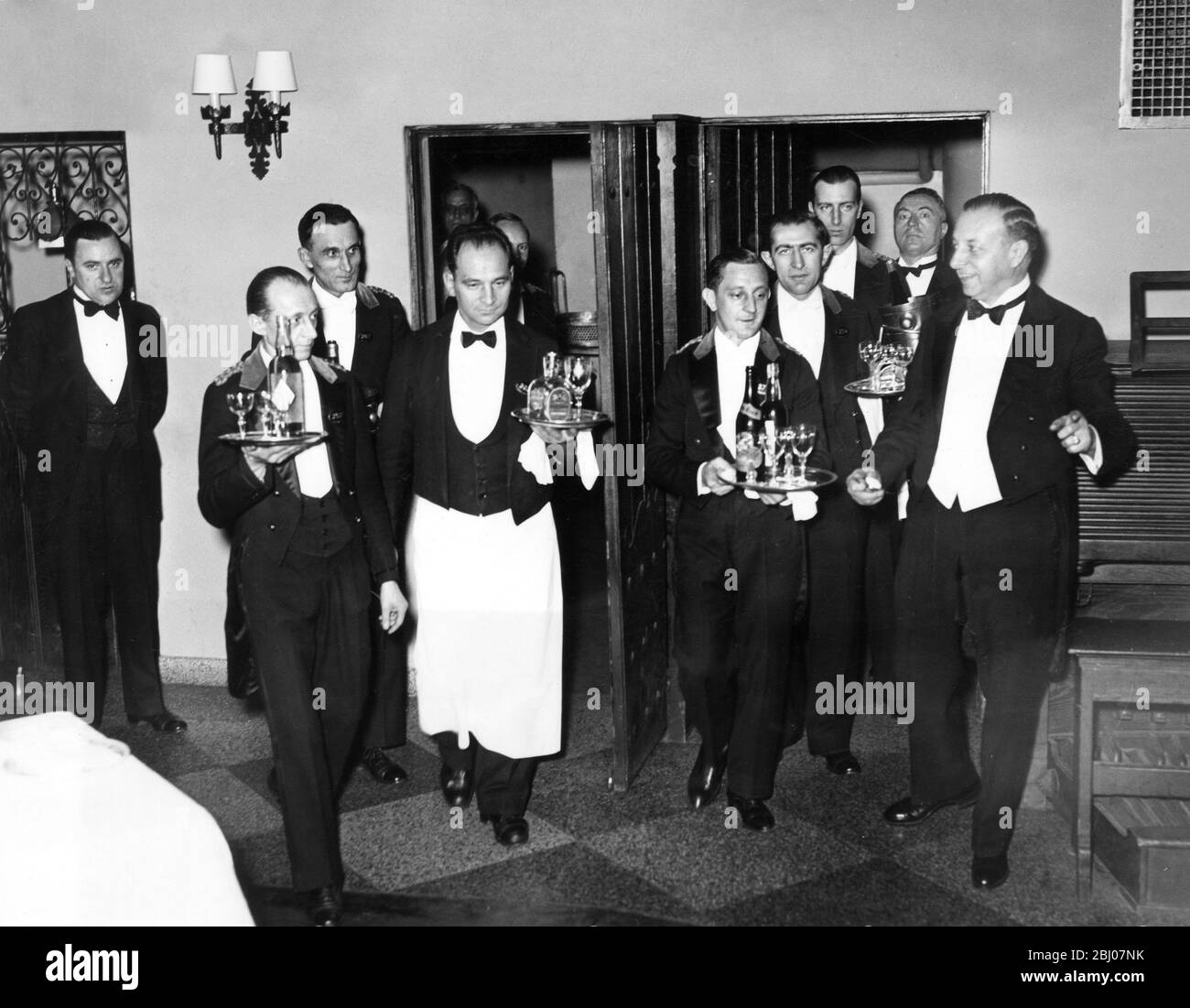 Ready to serve their patrons . - The holders of the liquor permit No.1 , which is held by the Hotel Astor , New York , did not waste any time in preparing their waiters to start serving their patrons the moment the prohibition repeal became effective on 5 December . The photo shows the headwaiter motioning his waiters to start serving the thirsty patrons on exactly 5.31 , Eastern time when Utah voted the repeal of the 18 th Amendment . - 12 May 1933 Stock Photo