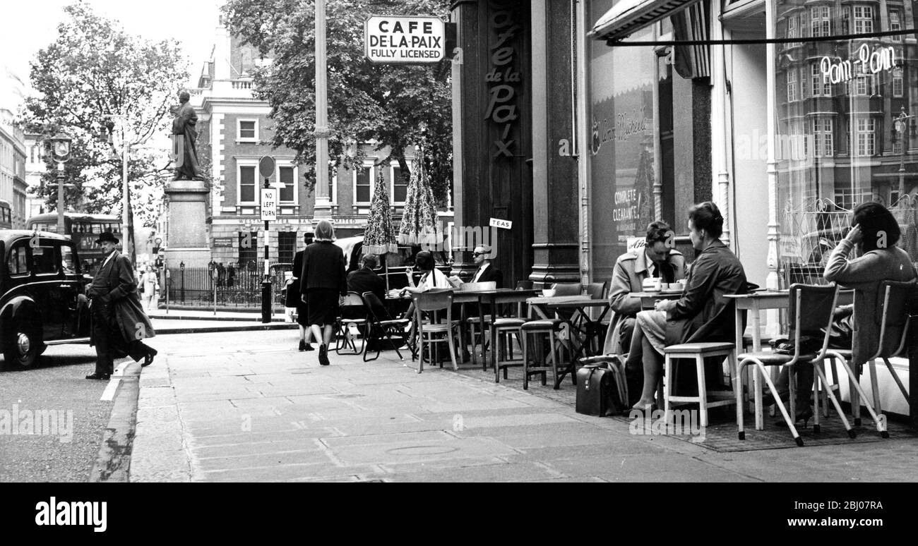 Despite the weather conditions which are more like winter in London , a few hardy people are seen taking their tea outside at this cafe near Hanover Square , London , England - 16 July 1963 Stock Photo