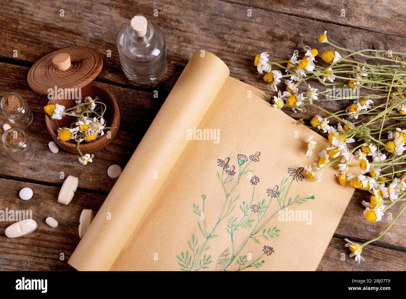 Old book with dry flowers in mortar on table close up Stock Photo