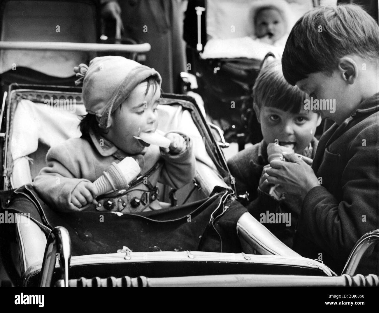 An amusing street incident - children eating ice creams and ice lollies . - Holyhead Anglesey . Spring 1959 Stock Photo