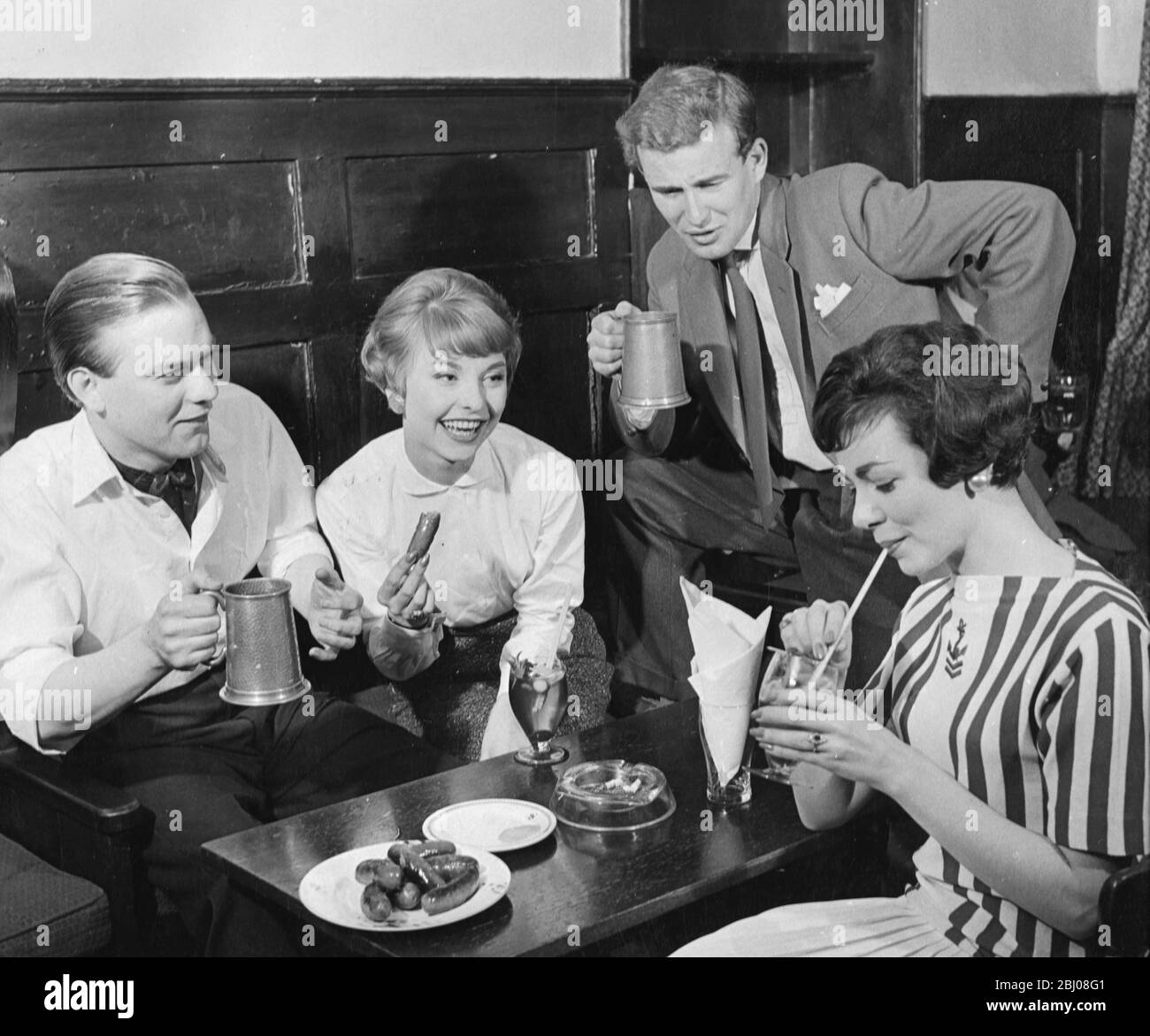 Two young couples enjoy drinks and pub food at the Spaniards Inn, Hampstead - 9 August 1958 Stock Photo