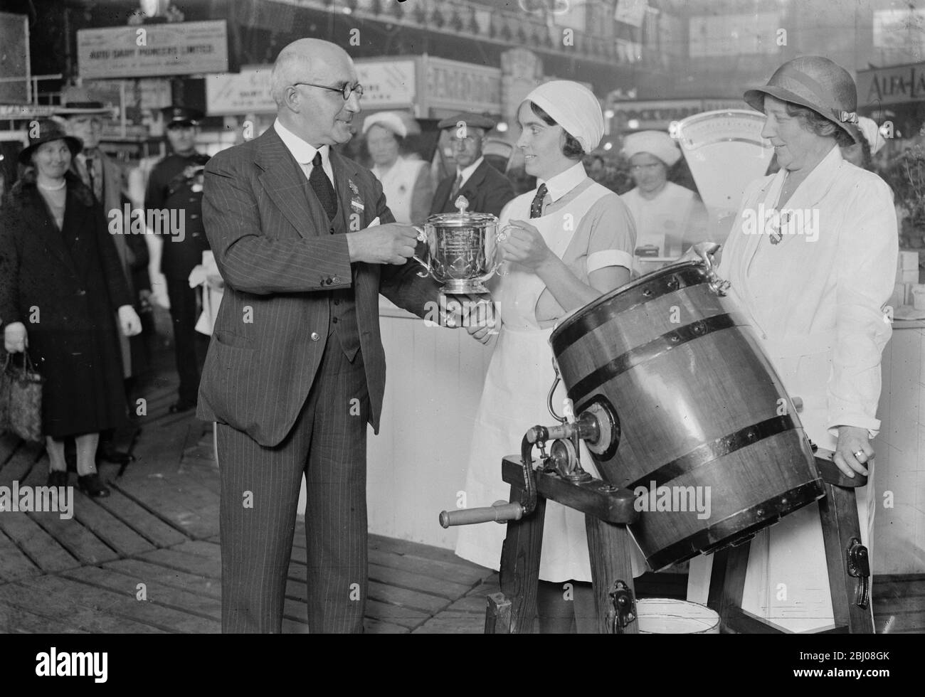 At the Dairy Show at the Royal Agricultural Halls , London . Mr Stapleton presenting the Championship Cup to Miss SM Stephens , Champion Dairymaid of Great Britain . - 20 October 1933 Stock Photo
