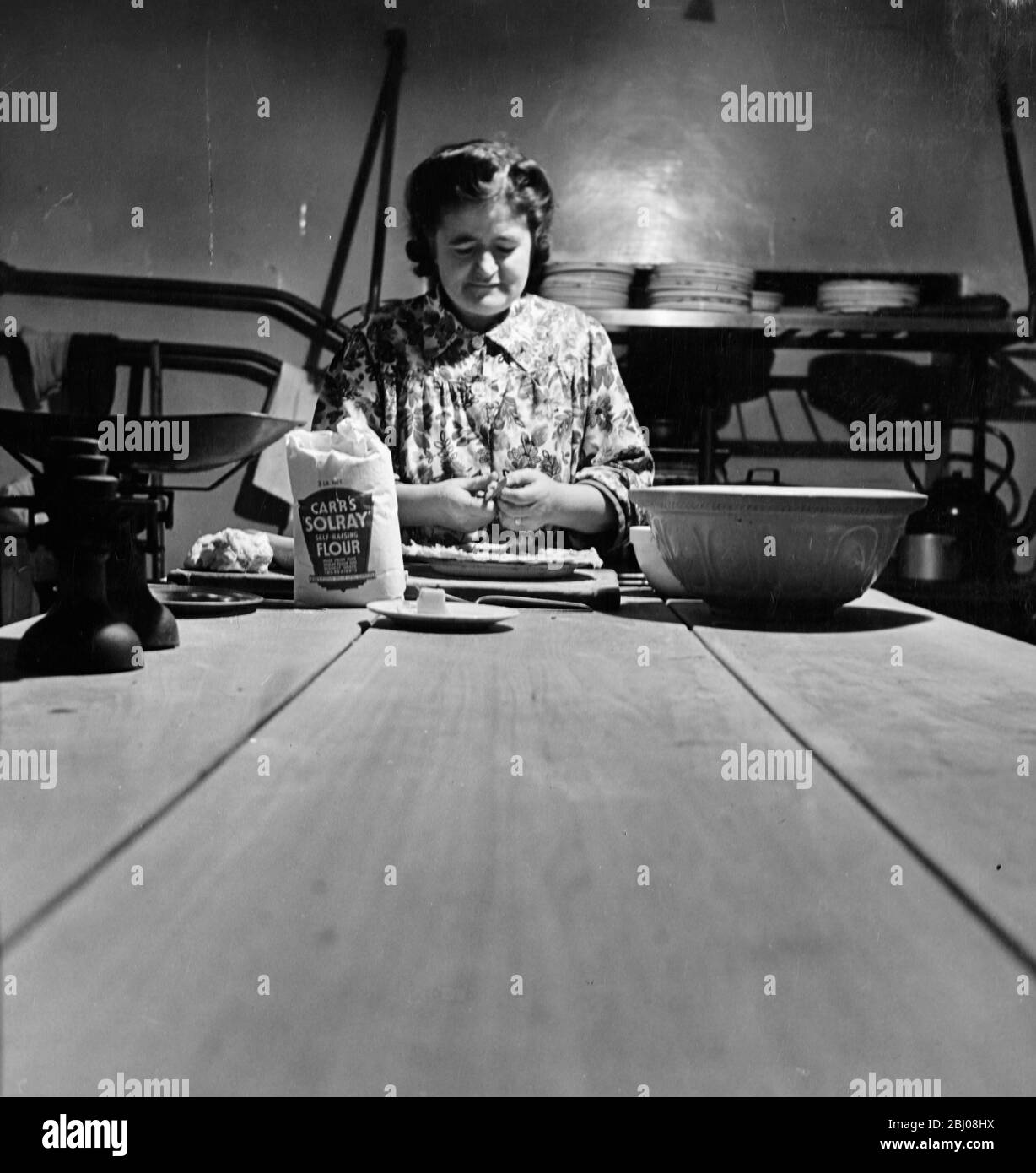Mrs. Temperley prepares a pie in the kitchen of the Globe Tavern. A state owned pub in Longtown, Carlisle, Cumbria, England. - December 1948 Stock Photo