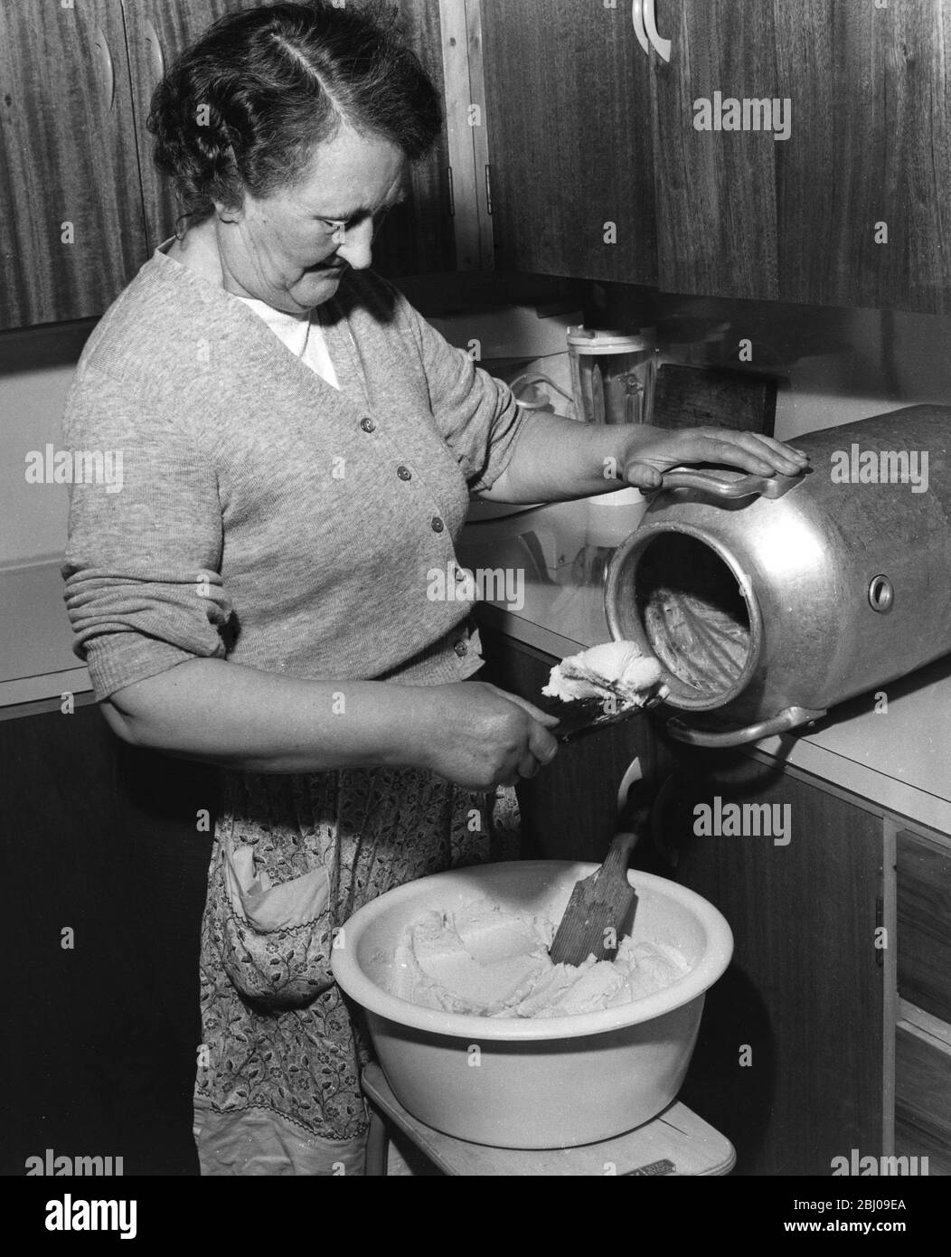 Making butter using the plunger in Orkney Outer Hebridges Scotland - September 1961 Stock Photo