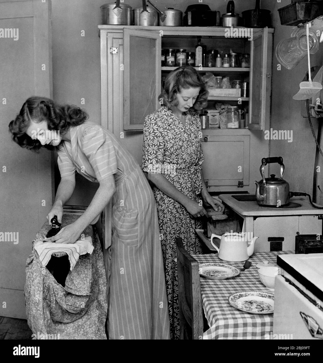 Chorus girls Phyllis Thompson and Riccy Chisholm in their tiny kitchen. - Stock Photo