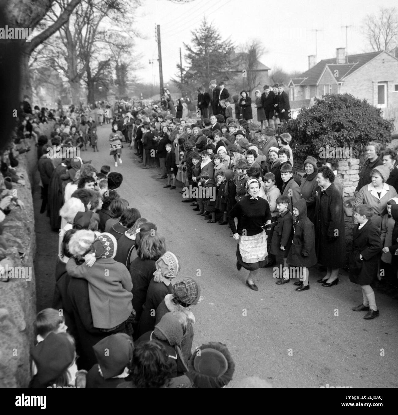 11 FEBRUARY 1964 - BRIDGET LOWRIE - 29 YEAR OLD MOTHER OF TWO IS THE WINNER OF THE OLNEY PANCAKE RACE AFTER COMPLETING THE 415 YARD COURSE IN 1 MINUTE 6.4 SECONDS. THE RACE DATES BACK TO 1445 AND WAS REVIVED BY THE LOCAL VICAR IN 1946. - OLNEY, BUCKINGHAMSHIRE, ENGLAND Stock Photo