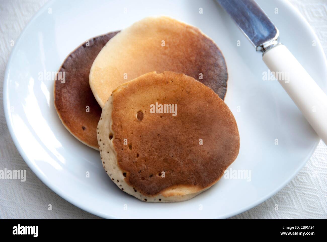 Three Scotch pancakes on a white plate Stock Photo