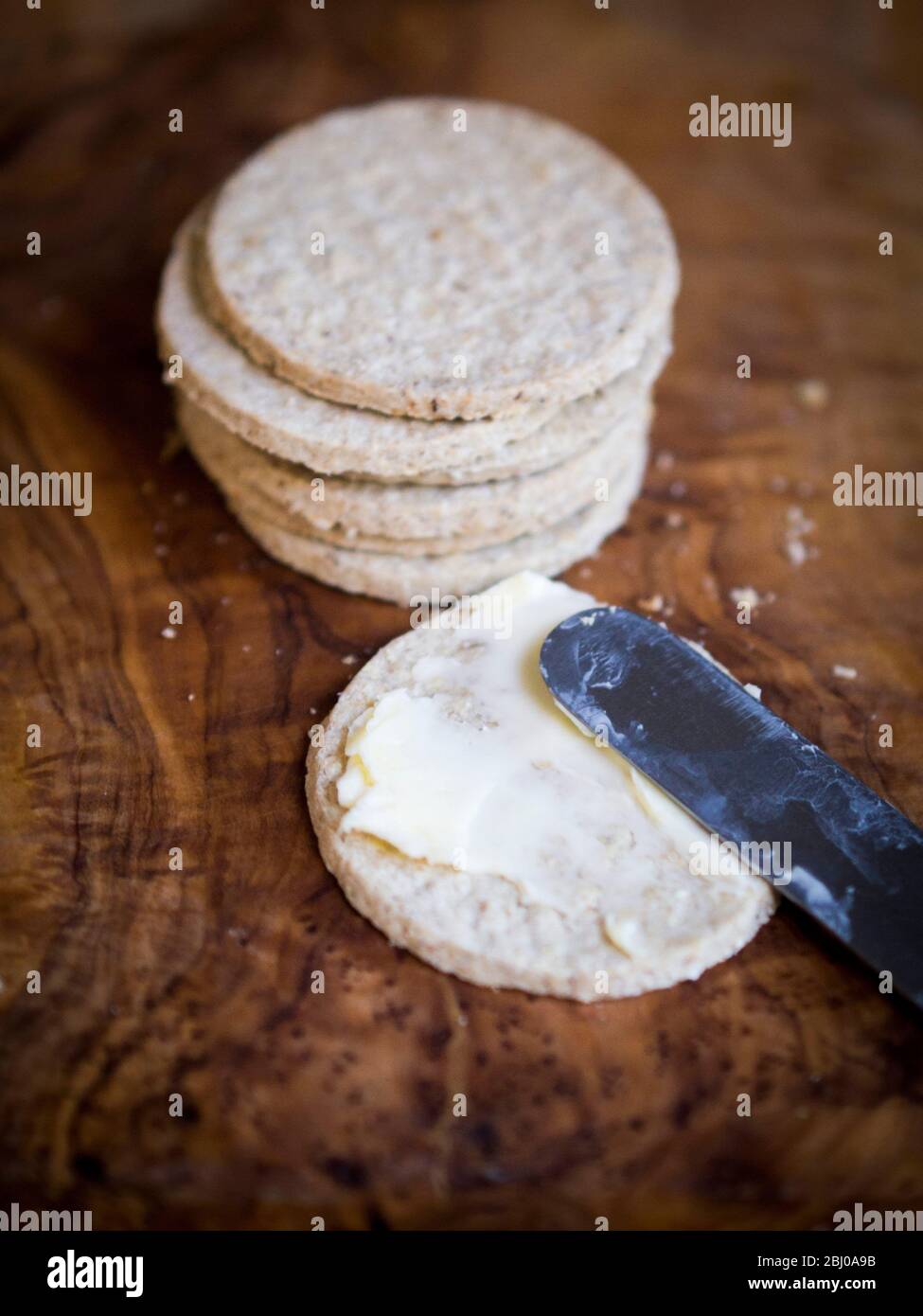 Gluten free Nairn's oatcakes spread with proper unsalted butter Stock Photo