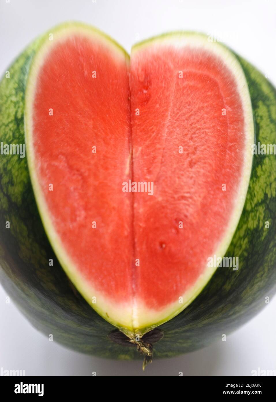 Cut face of watermelon showing flesh and seeds in interior - Stock Photo