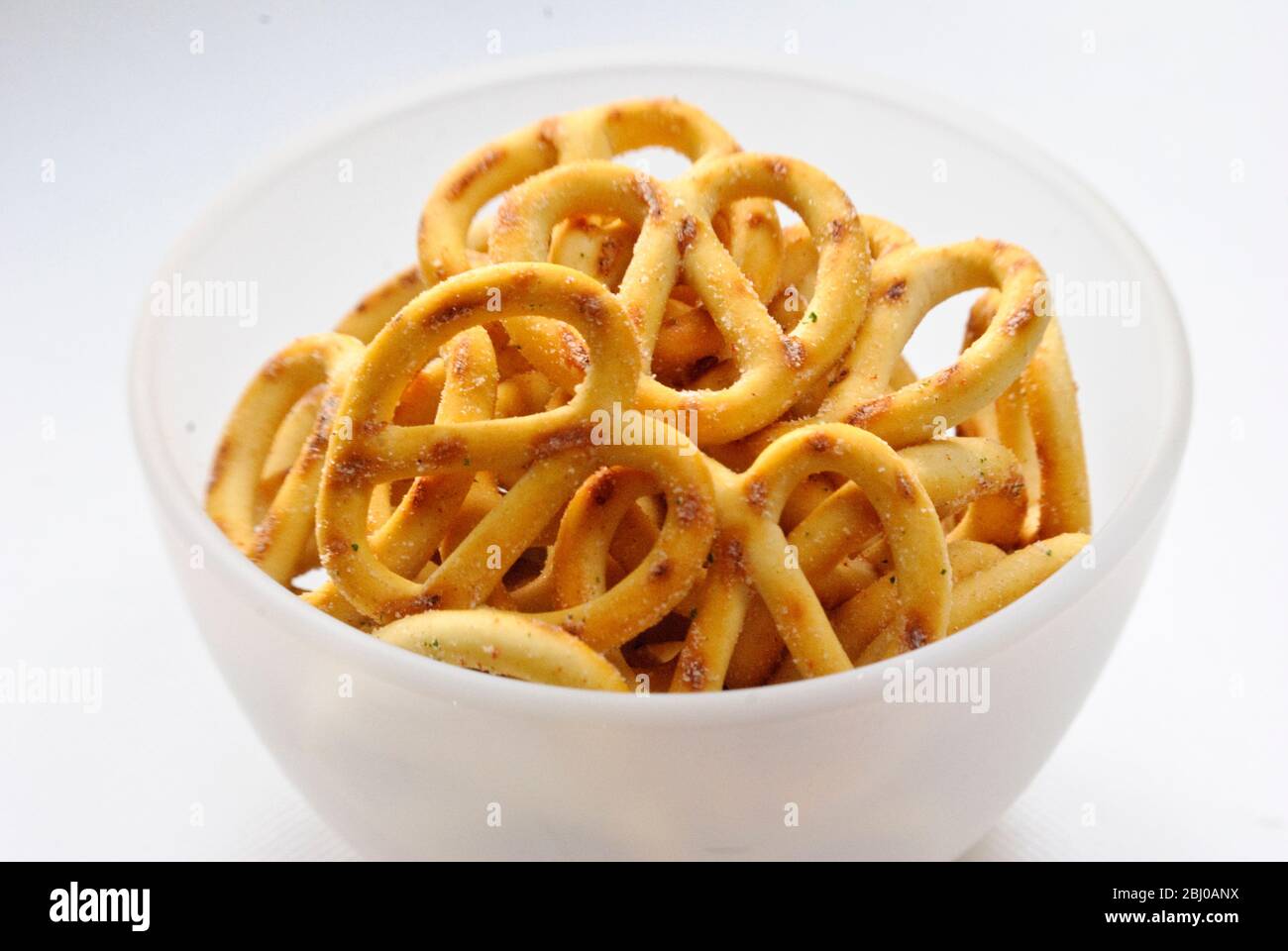 Small ground glass bowl of sour cream flavoured pretzels - Stock Photo