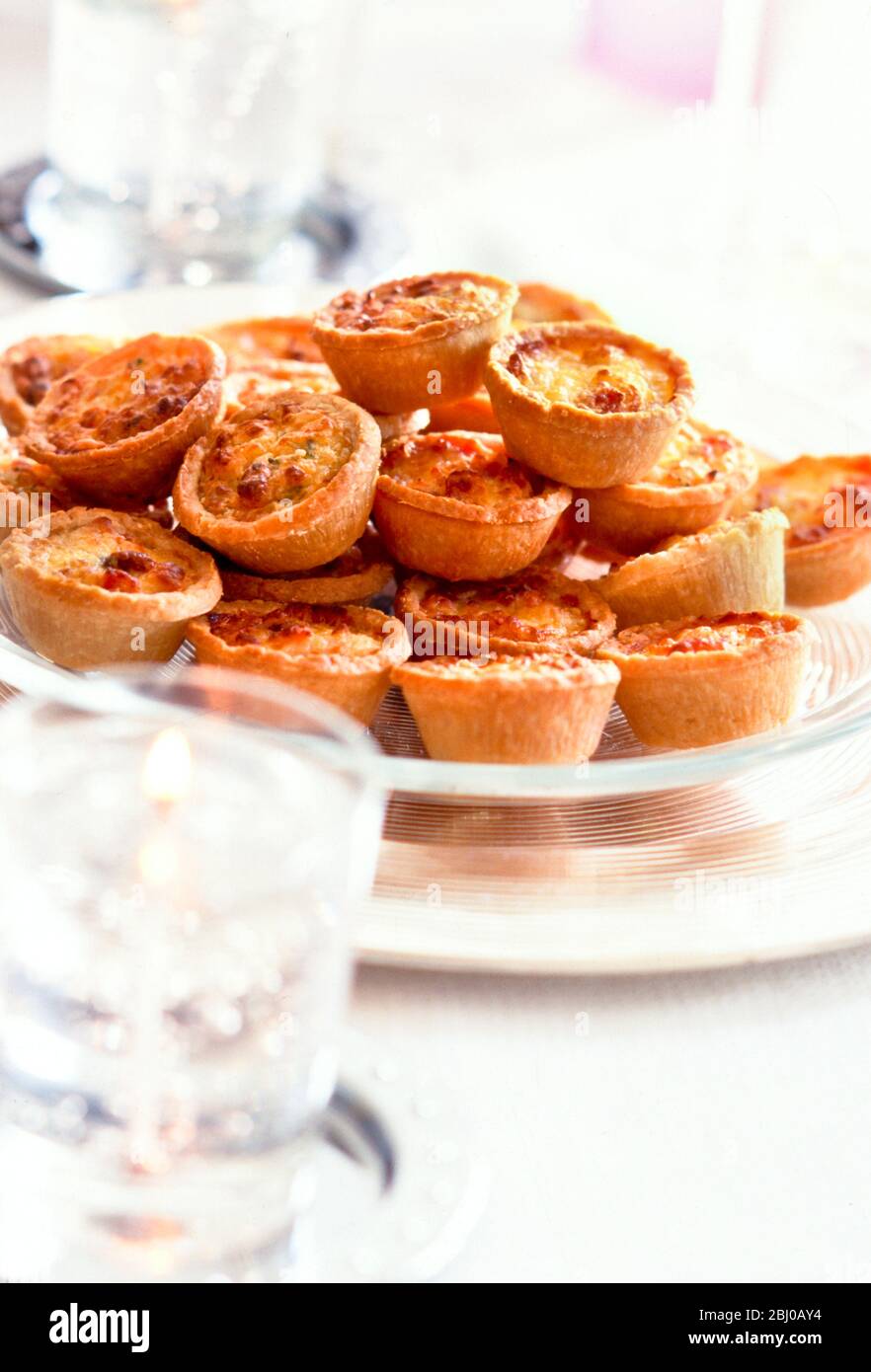 Dish of mini quiches served as canapes at party or reception - Stock Photo
