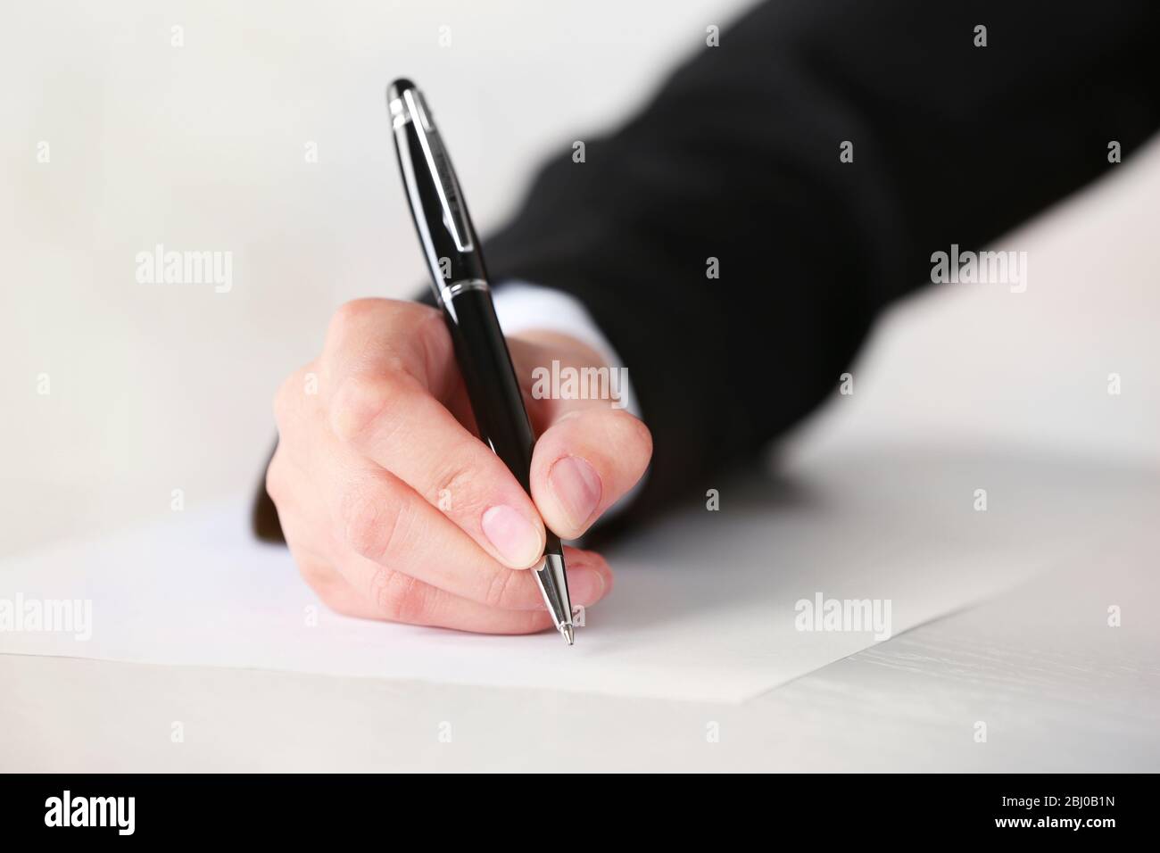 Female hand with pen writing on paper at workplace Stock Photo - Alamy