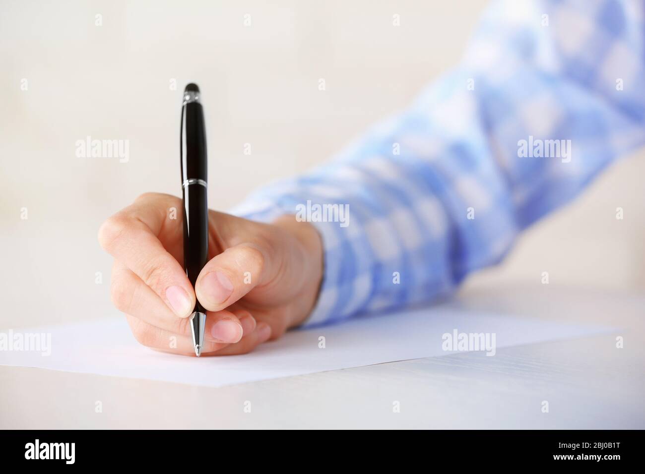 Female hand with pen writing on paper at workplace Stock Photo - Alamy