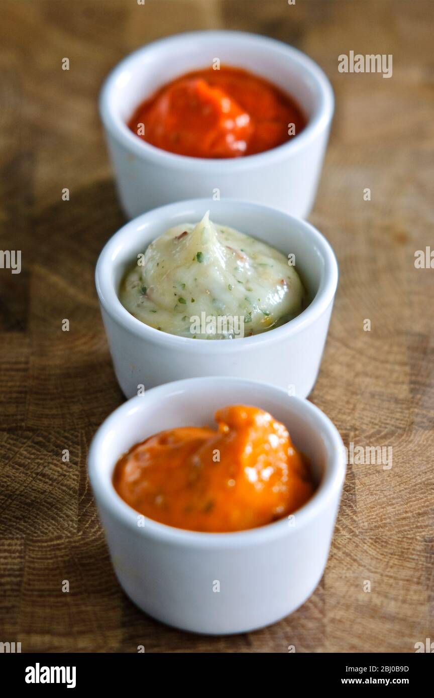 Small pots of commercial sauces used for glazing meaat before grilling. Also can be used as relish - Stock Photo