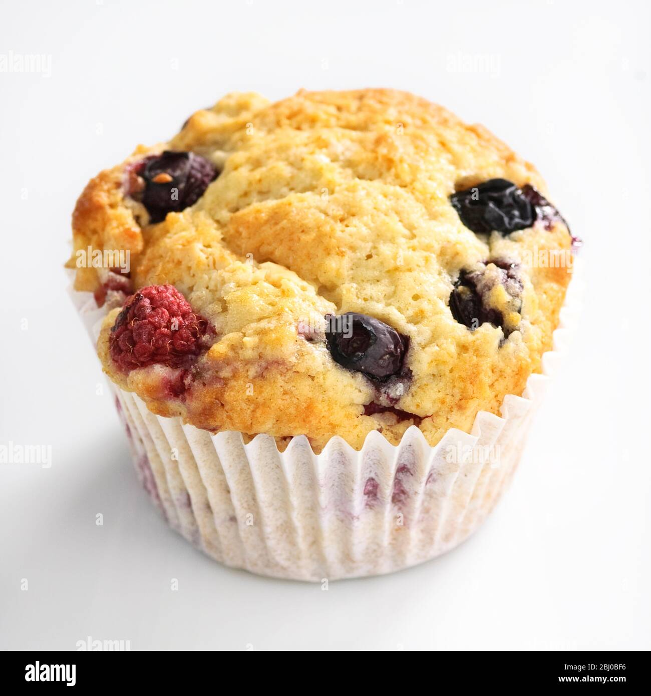 MIxed berry muffin with blueberries and raspberries in paper case - Stock Photo