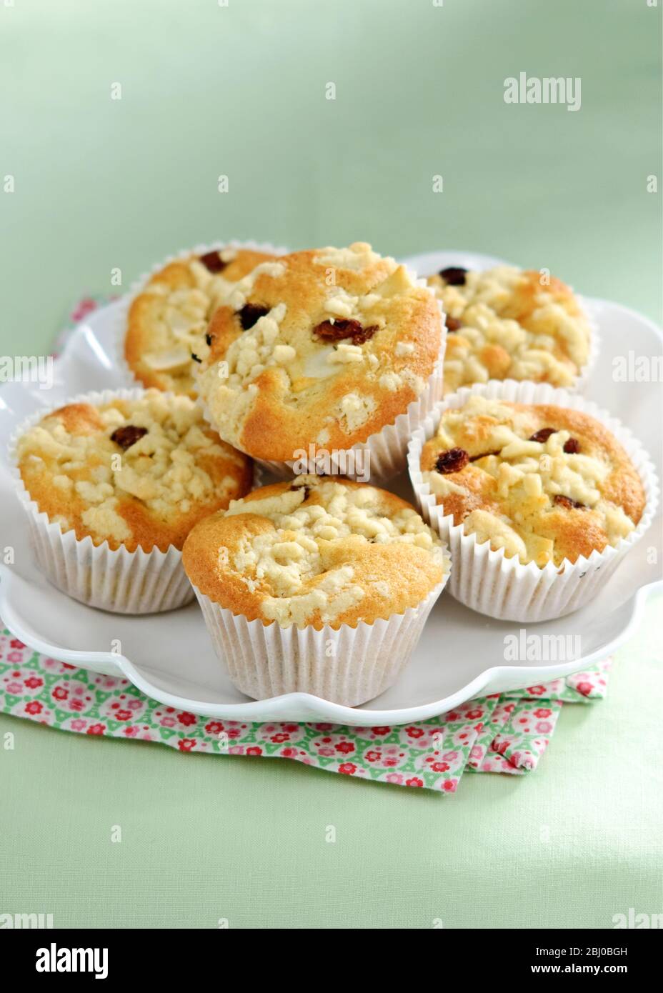 Apple struesel muffin in pile on white plate - Stock Photo