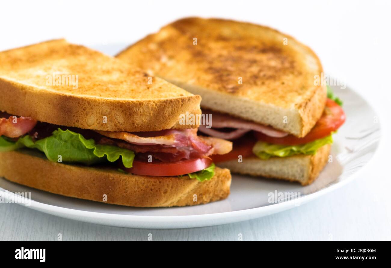 BLT, Bacon Lettuce and Tomato sandwich on toasted white bread. - Stock Photo