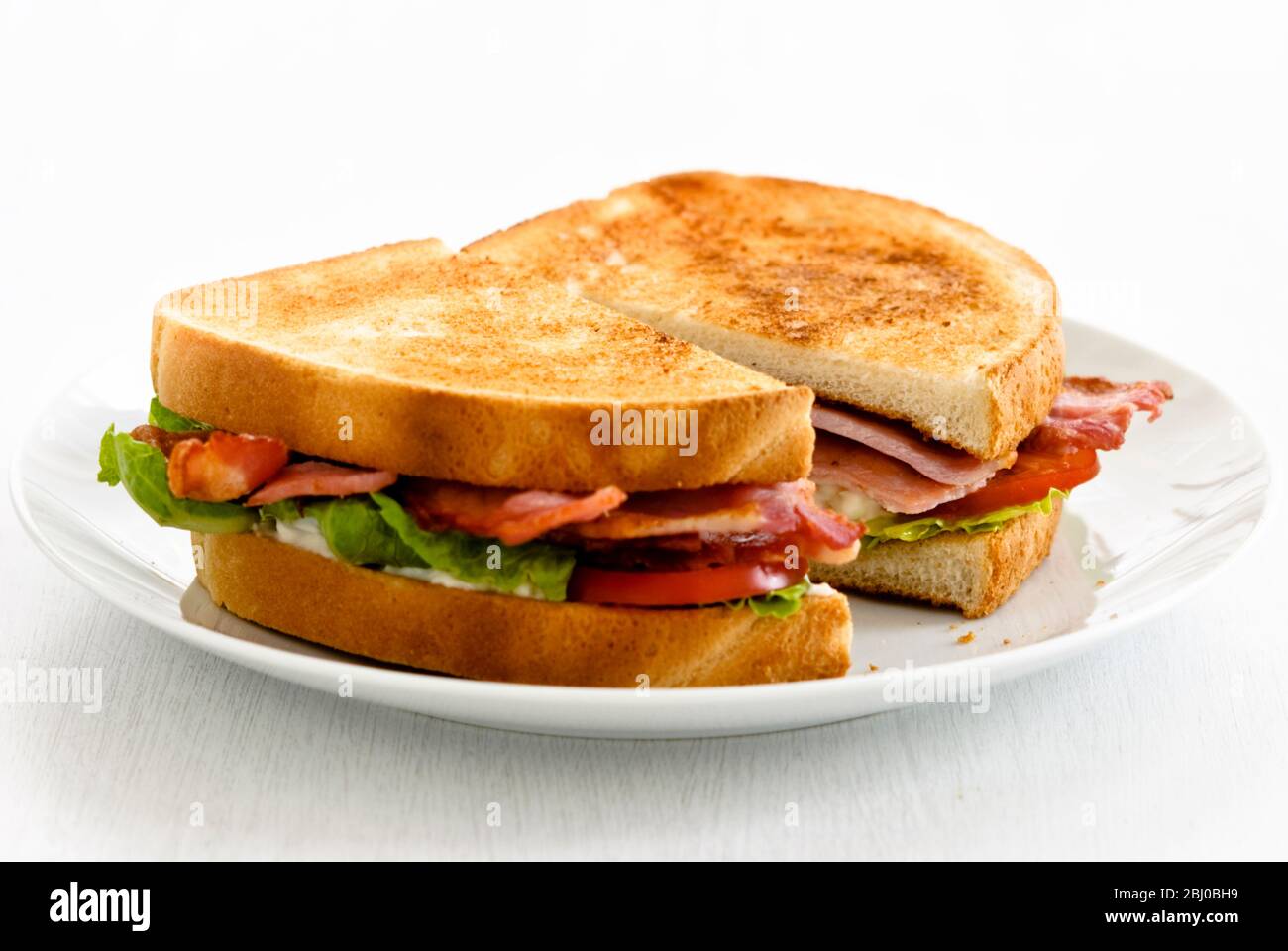 BLT, Bacon Lettuce and Tomato sandwich on toasted white bread. - Stock Photo