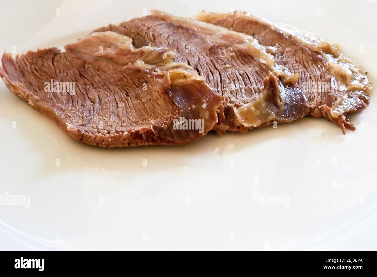 Three slices of boiled mutton on white plate. Return of a British classic, unappreciated for many years, but now mutton is again available from seriou Stock Photo
