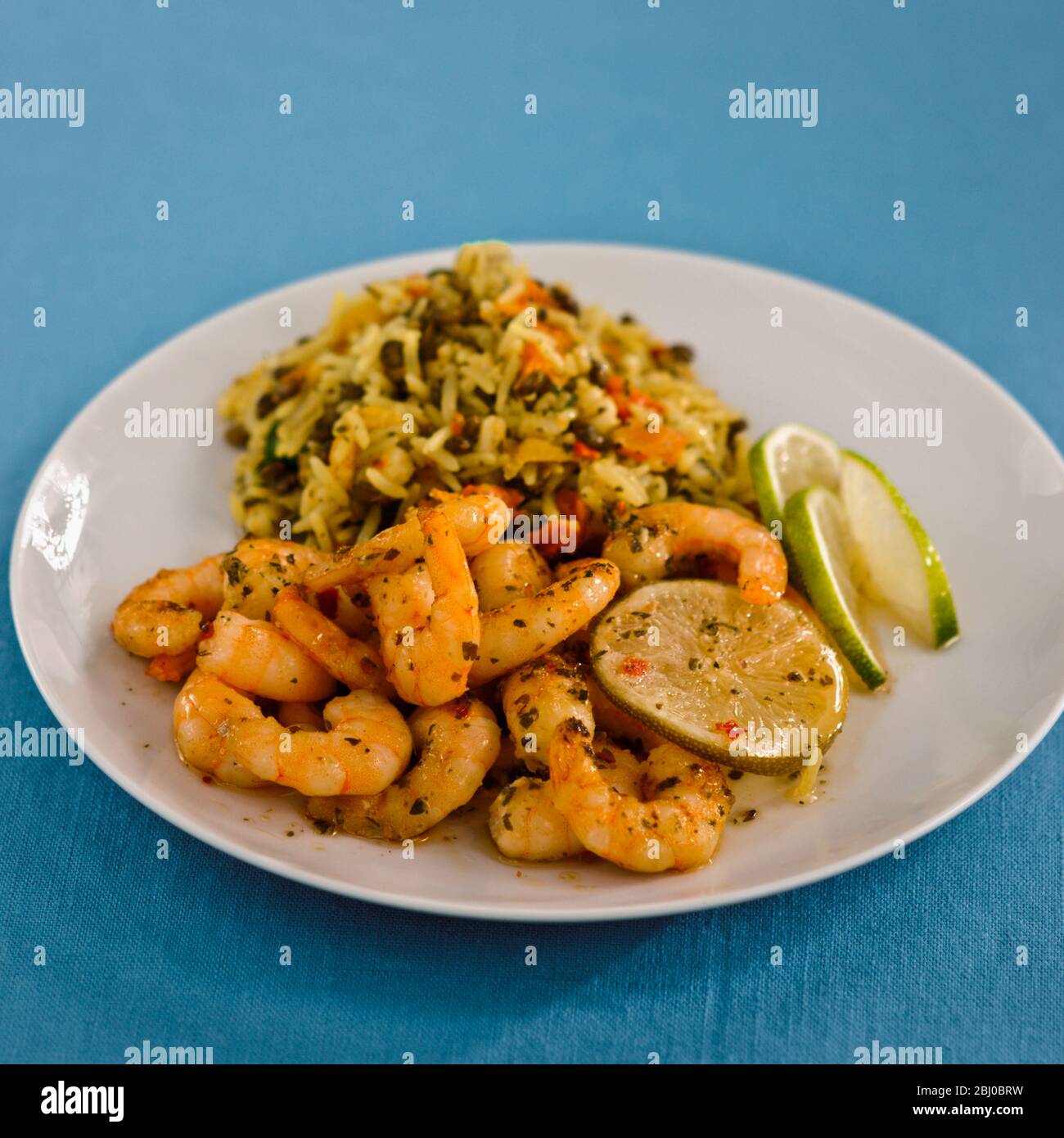 Spicy Thai stir fried king prawns with herbed rice - Stock Photo