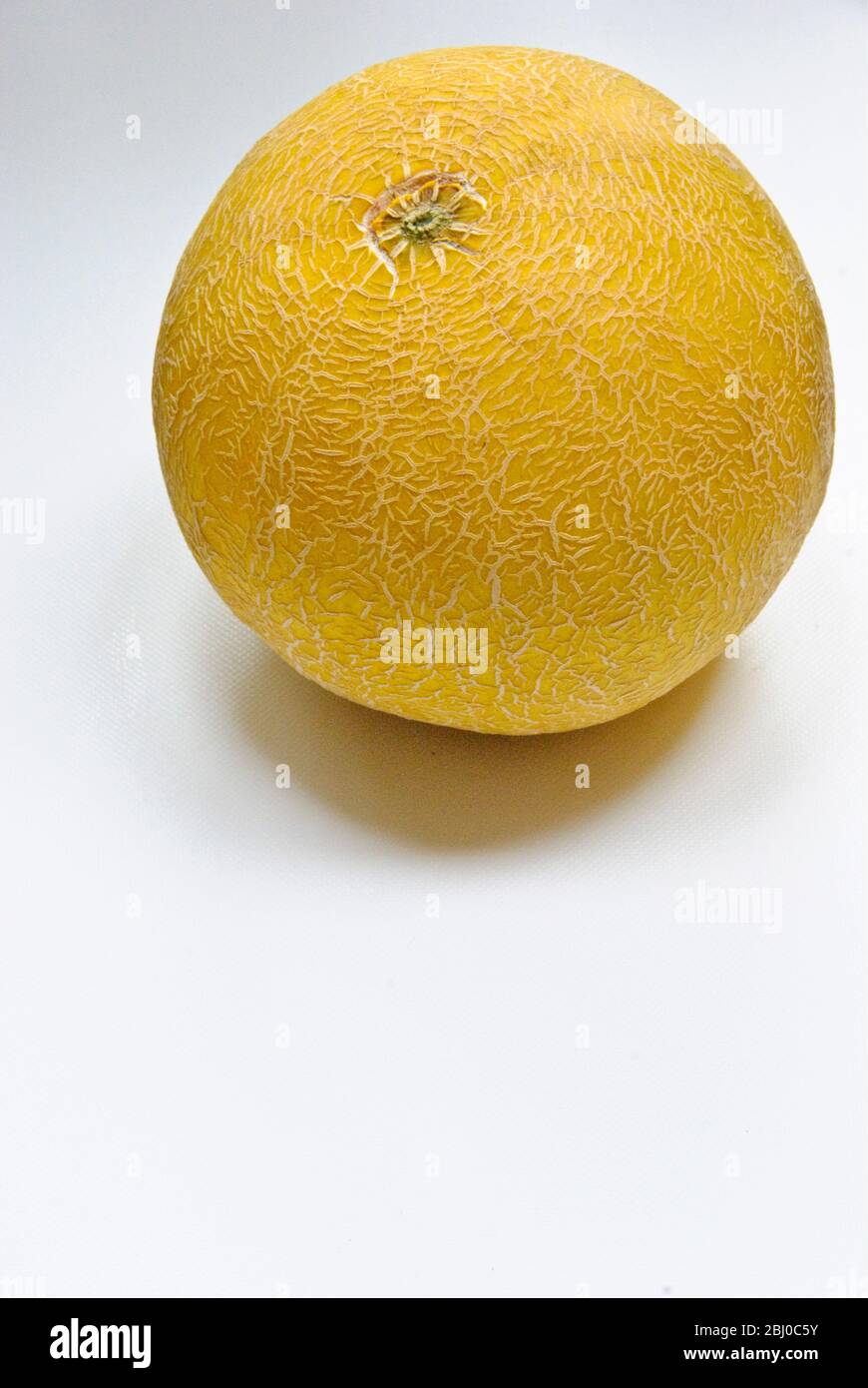 Whole gallia melon on white surface - Stock Photo