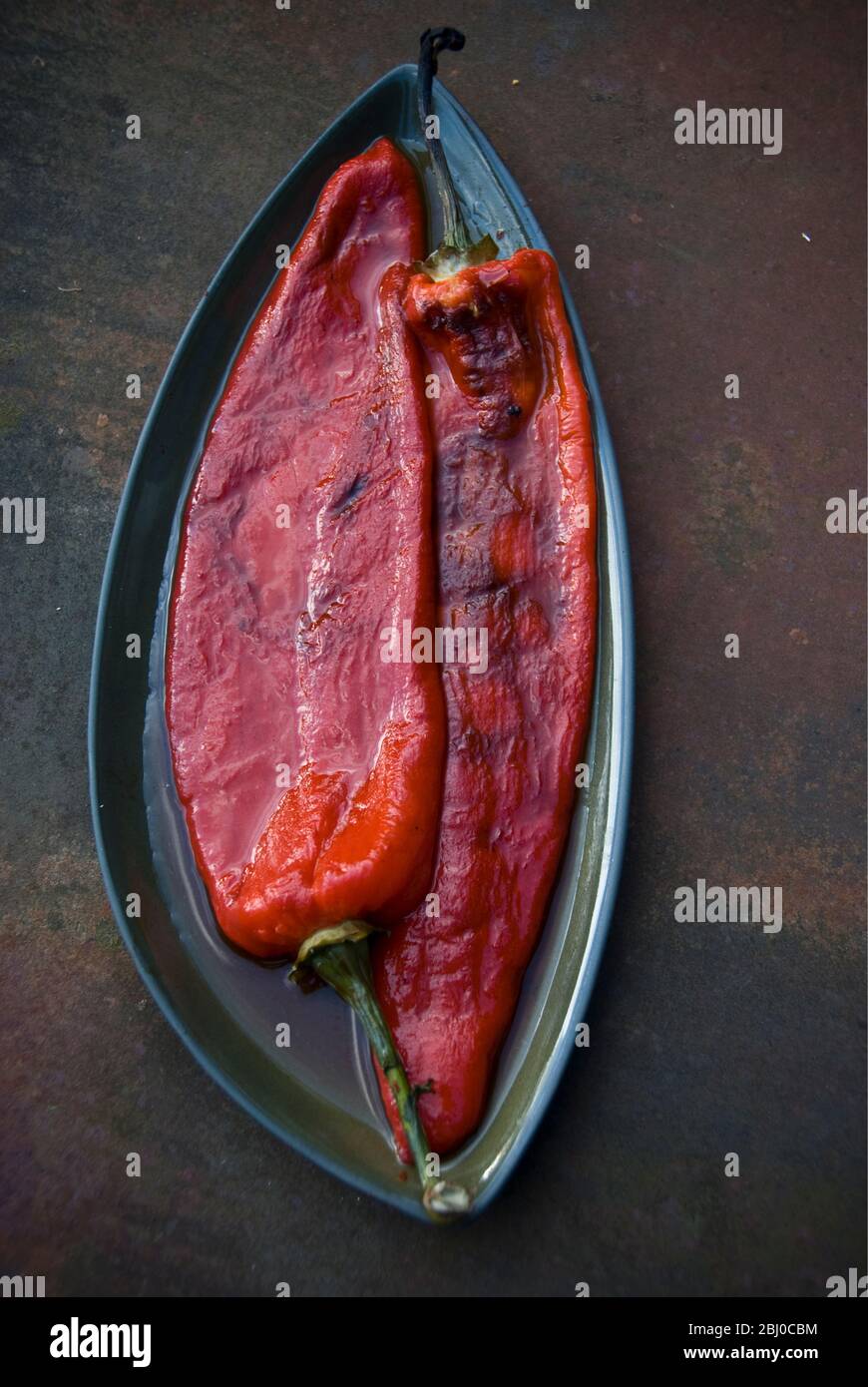 Grilled red peppers with blistered skins removed - Stock Photo