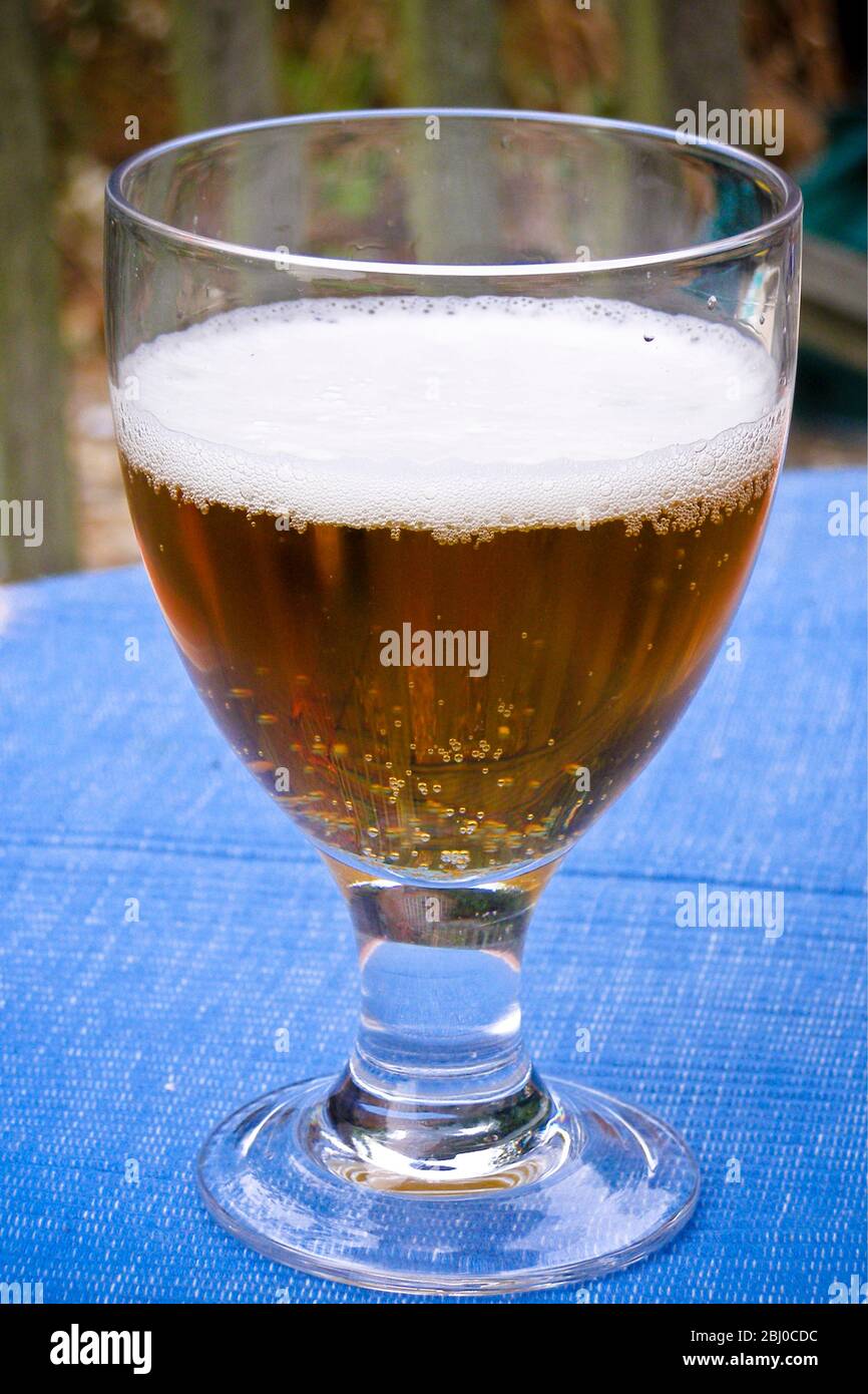 Glass of beer outside on summer evening - Stock Photo