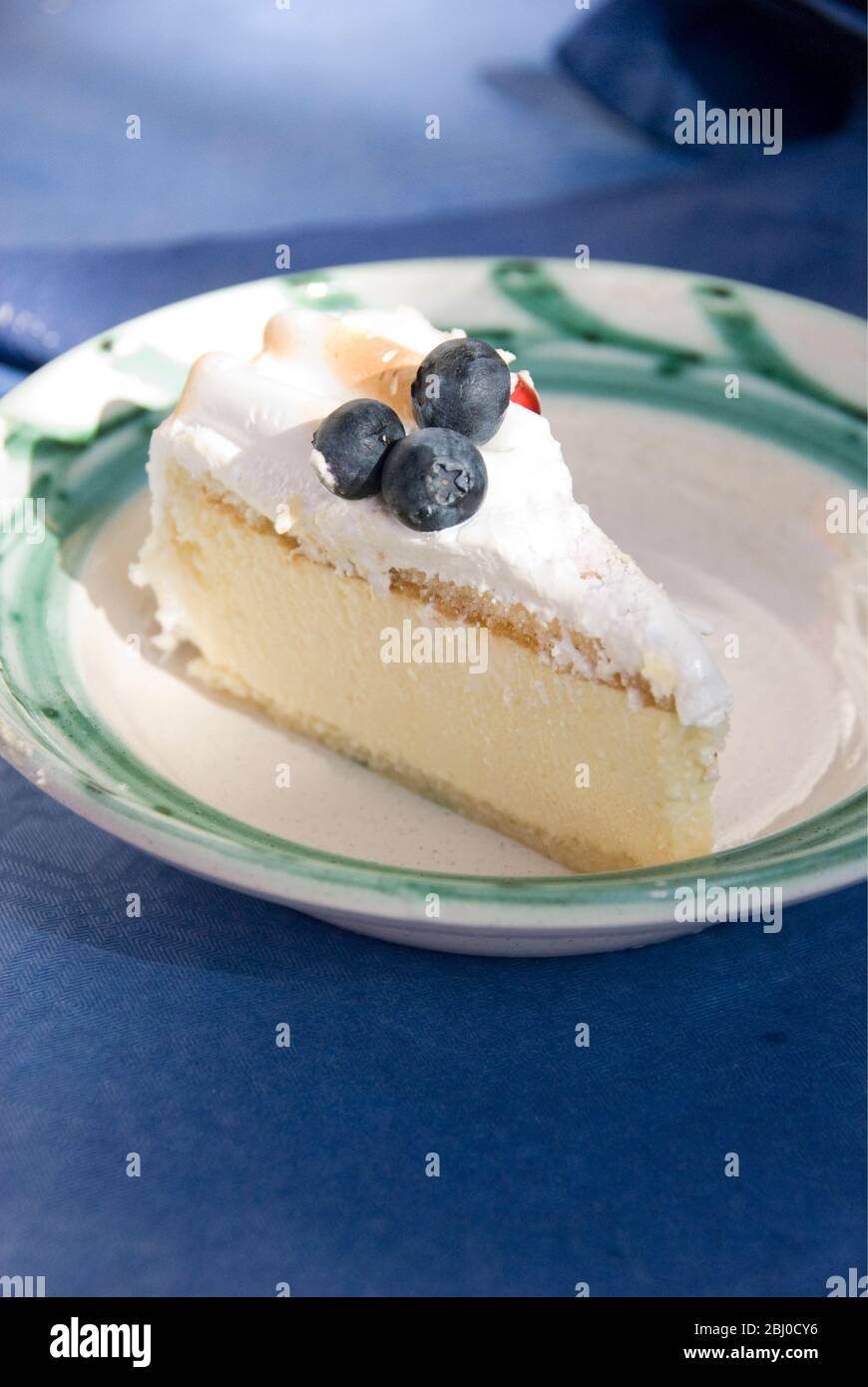Slice of celebration gateau of light lemon and passionfruit mousse with soft meringue topping. - Stock Photo