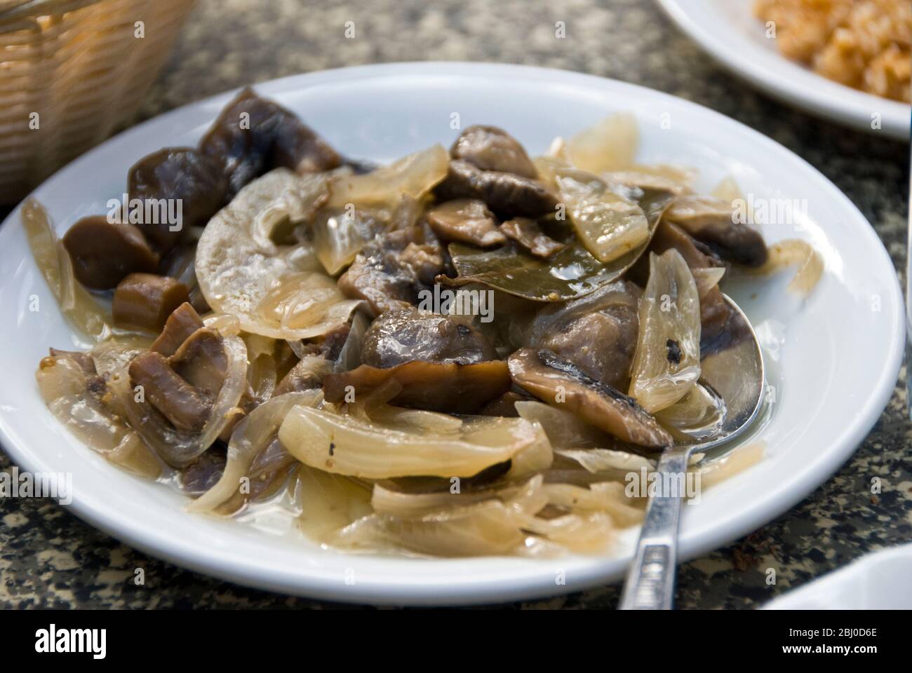 Mushrooms cooked with garlic and onions served as part of meze in Greek Cypriot restaurant in the mountains in southern Cyprus - Stock Photo