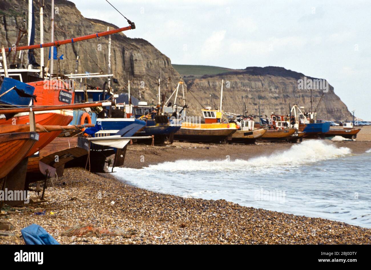 Fishing boats pulled up onto the shingle at Hastings, Sussex, UK - Stock Photo