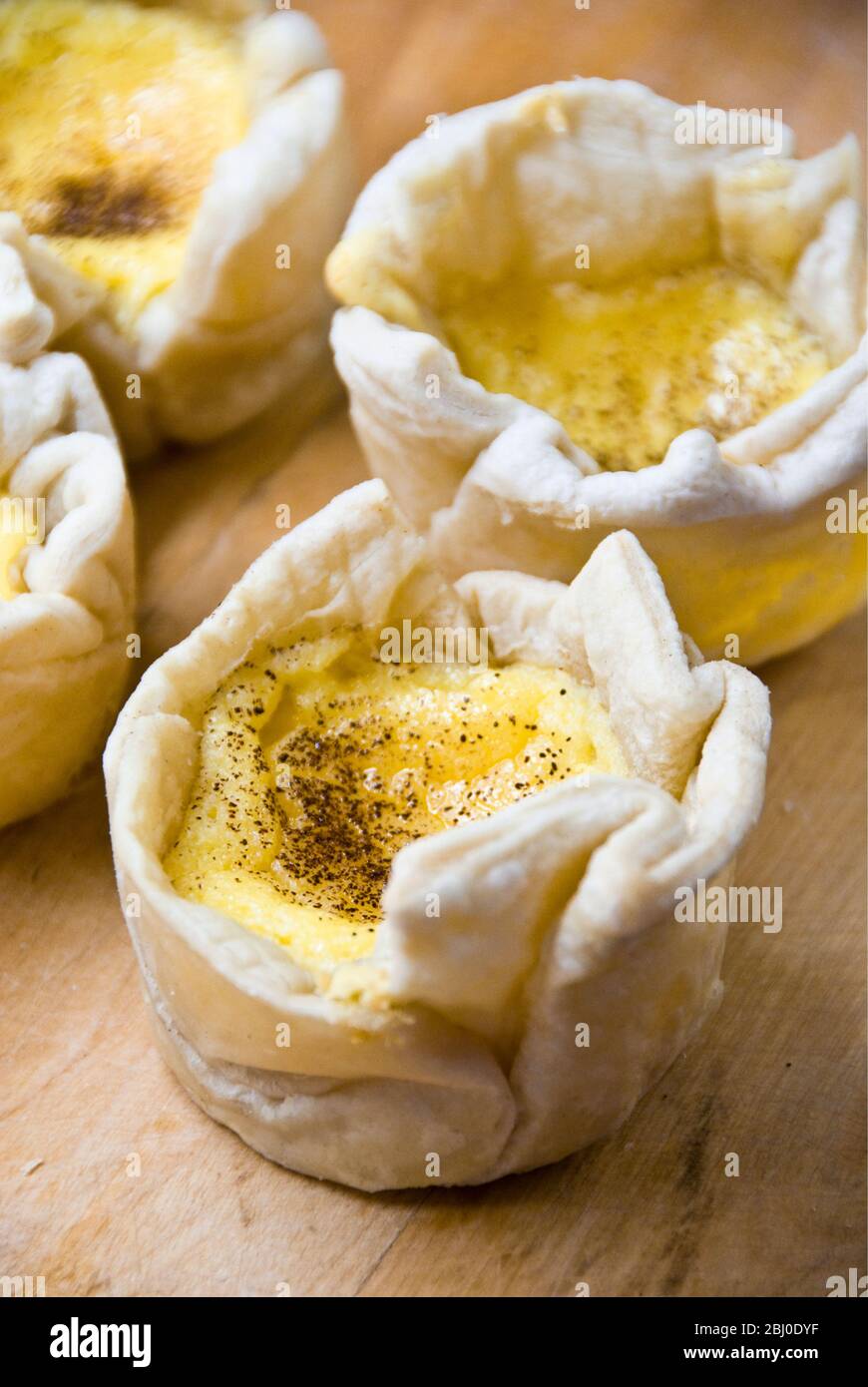 Home made portuguese style custard tarts with confectioners' custard and puff pastry - Stock Photo