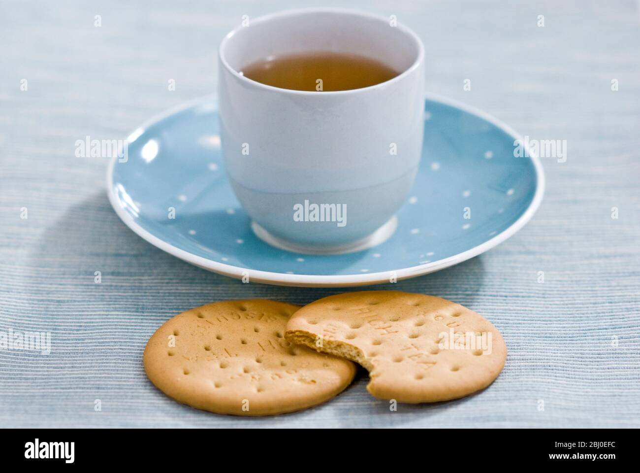 Two rich tea biscuits and a cup of green tea as a relaxing break - Stock Photo