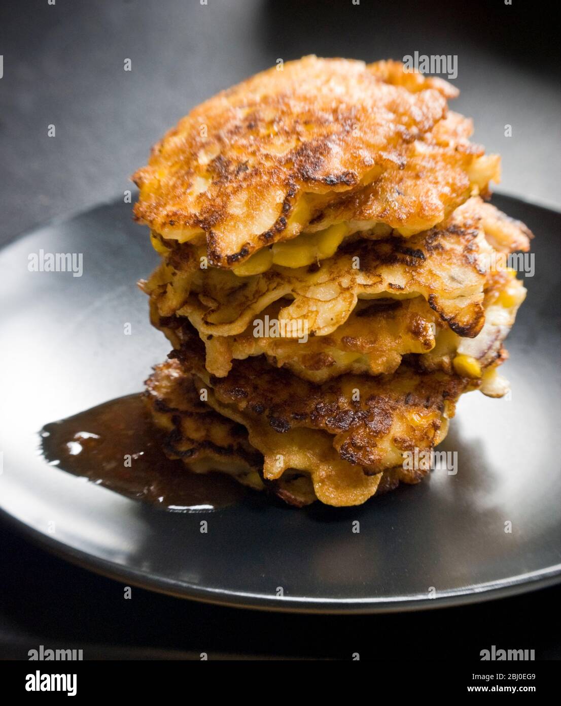Stack of sweetcorn and crab fritters, with sweet chilli sauce. - Stock Photo