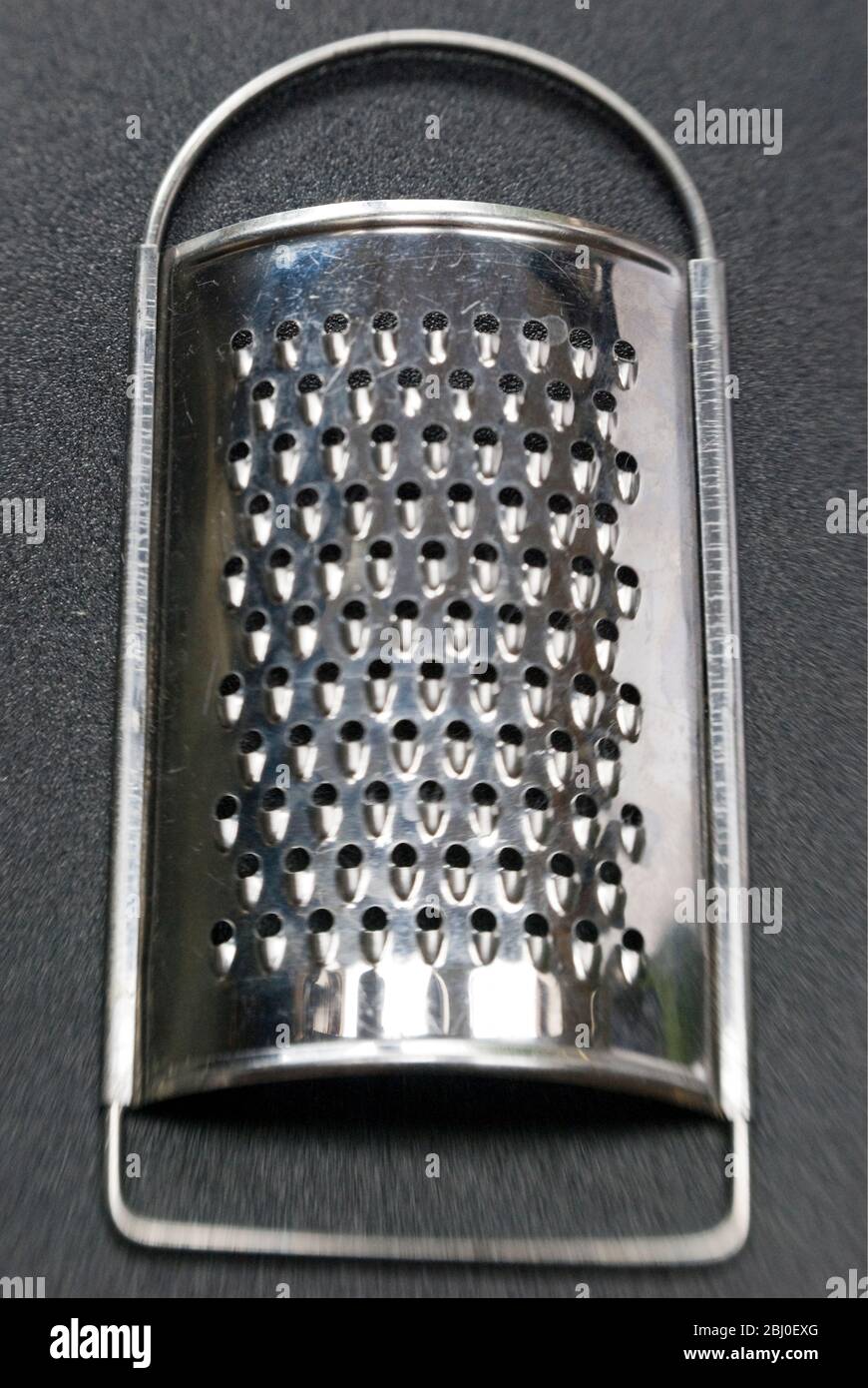 Handy little stainless kitchen grater. - Stock Photo